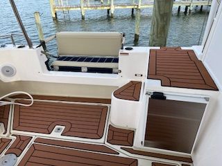 Ranger Tugs R 31 LE 2023 with teak flooring and a bench by the water.