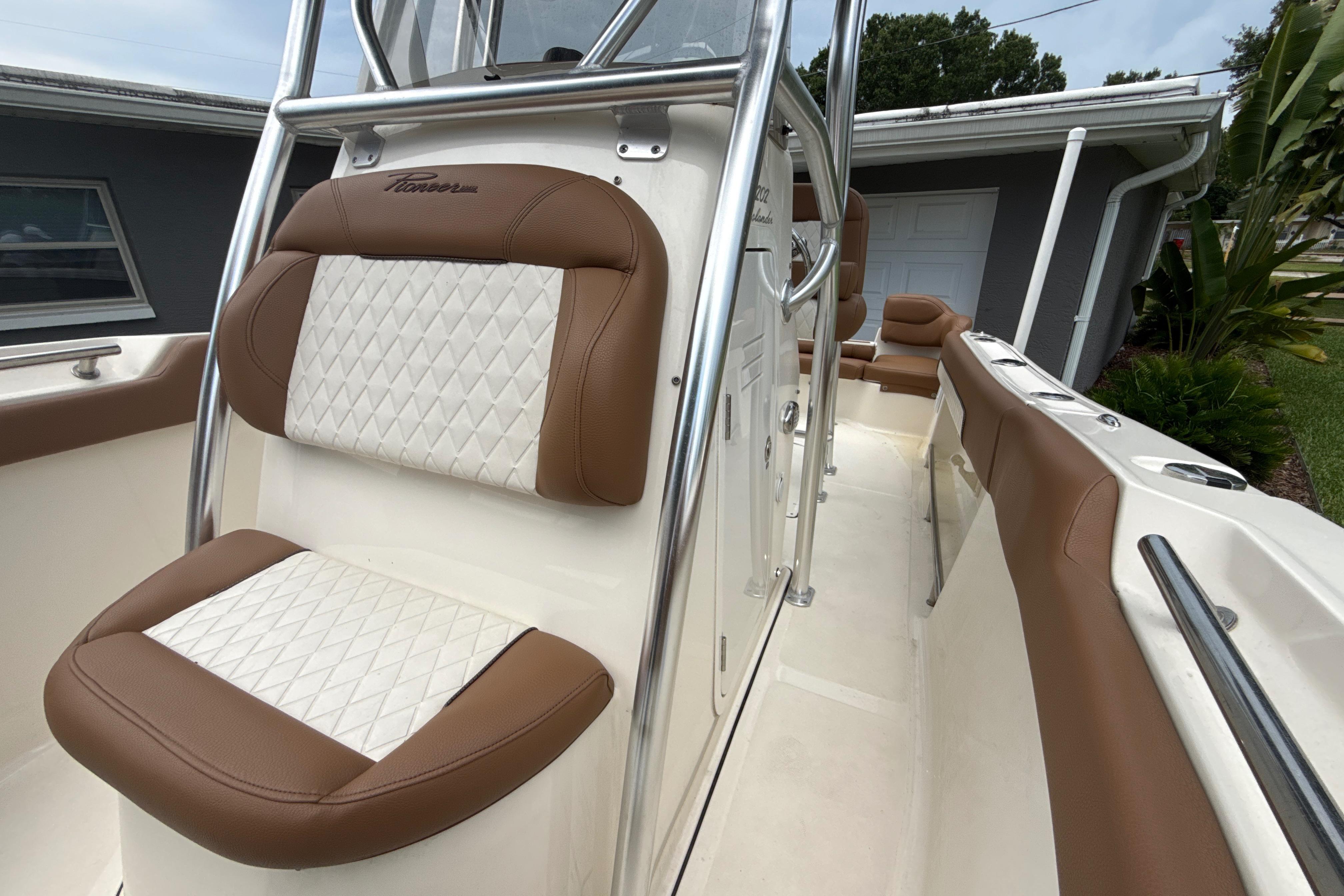 2023 Pioneer 202 Islander boat interior with brown and white cushioned seating.