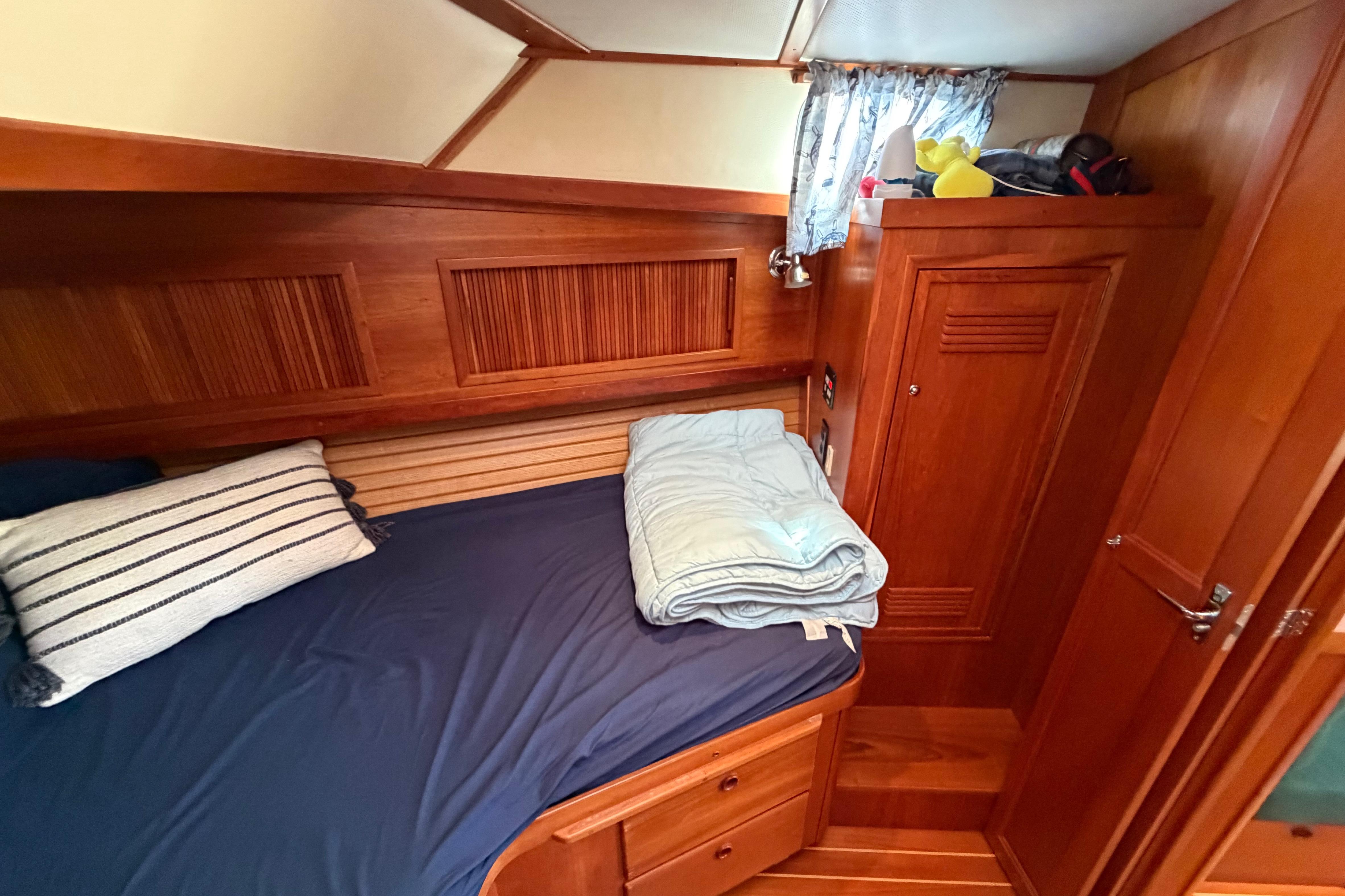 Cozy cabin interior of 2000 Sabreline 36 Express with wooden finish and bedding.