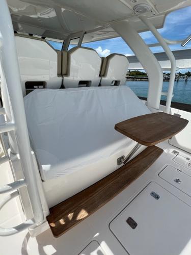 2019 Pursuit S 408 Sport boat interior with cushioned seating and wooden table.