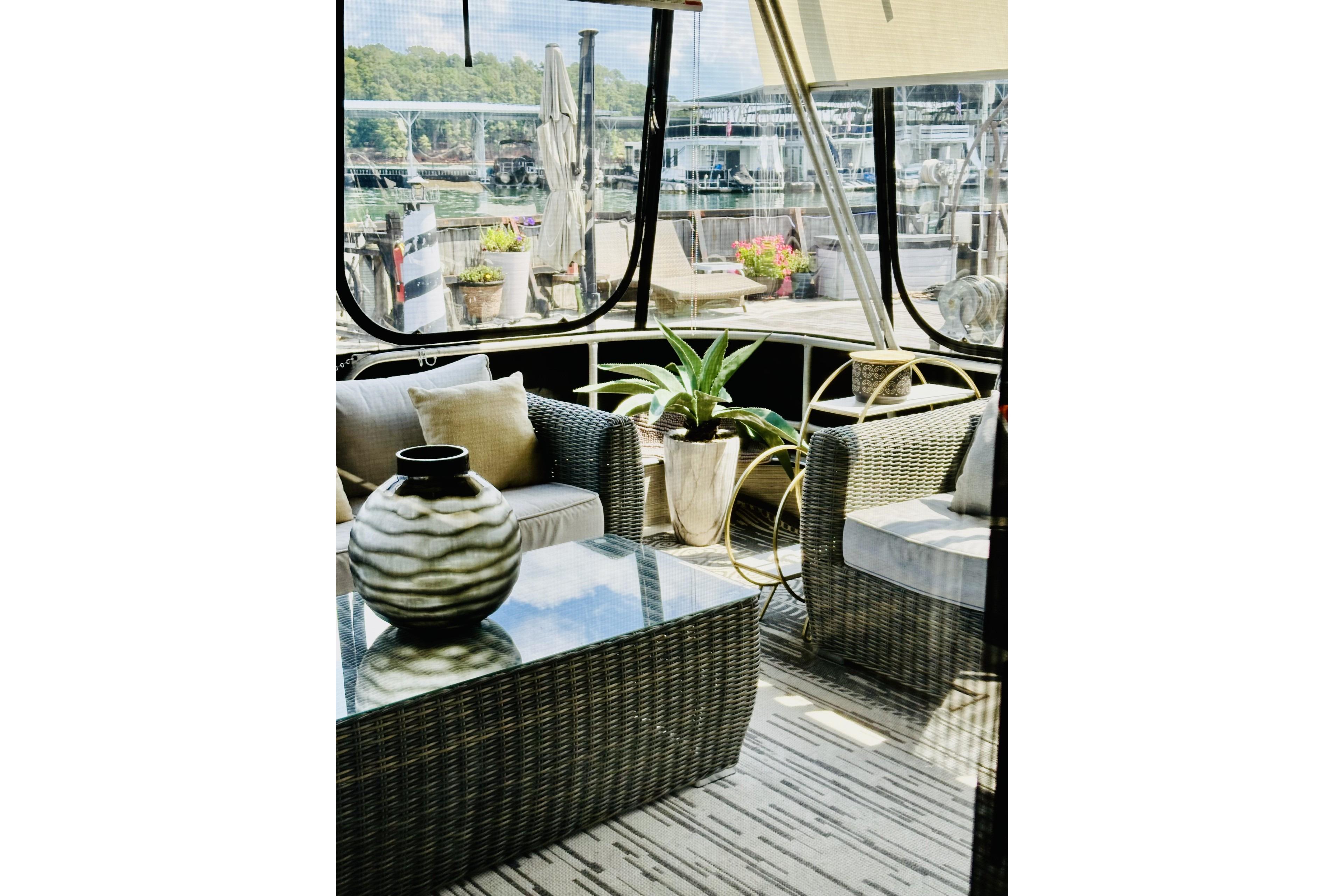 Luxurious 1992 Sumerset 66 houseboat interior with elegant wicker furniture and decorative plants.