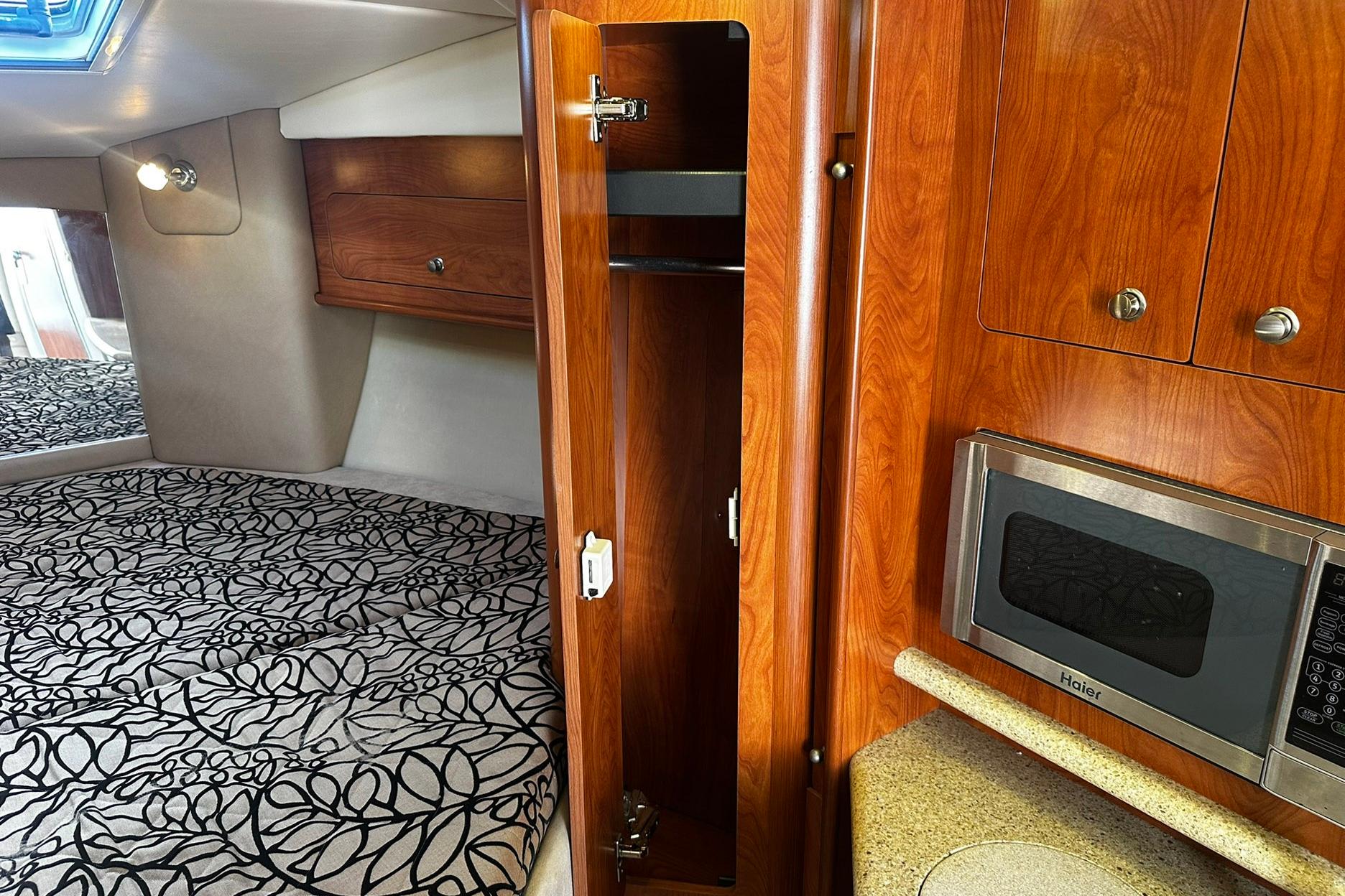 Interior of 2012 Rinker 310 Express Cruiser LE with wood cabinetry and microwave.