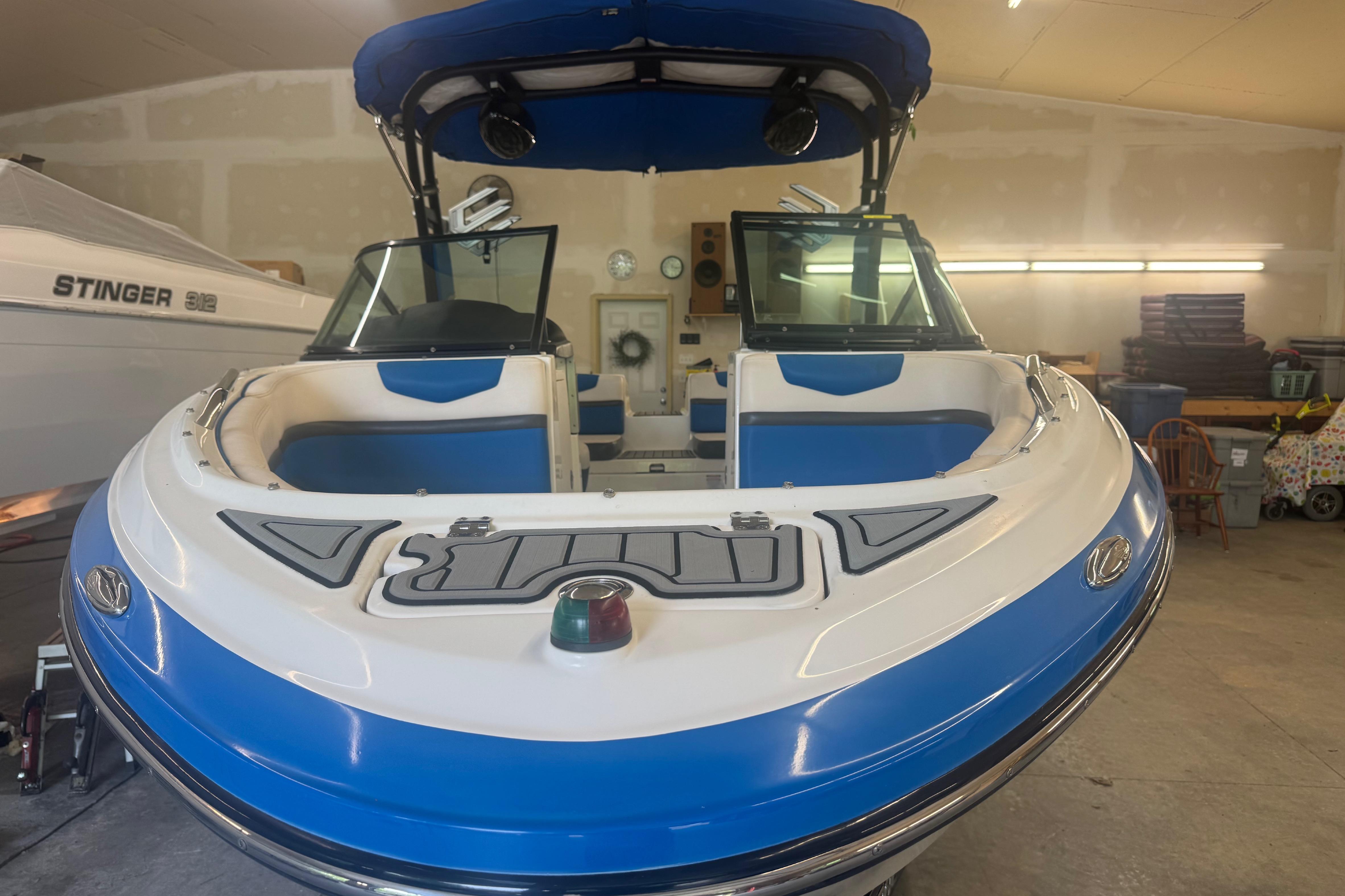 2017 Chaparral Vortex 203 VRX boat in garage, blue and white design, front view.