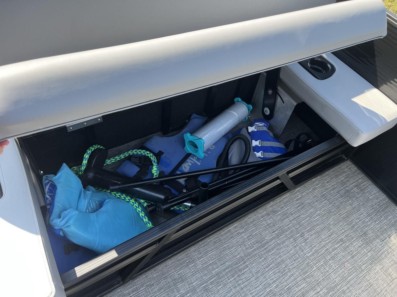 A storage compartment on a Bennington S20 boat with life jackets and ropes.
