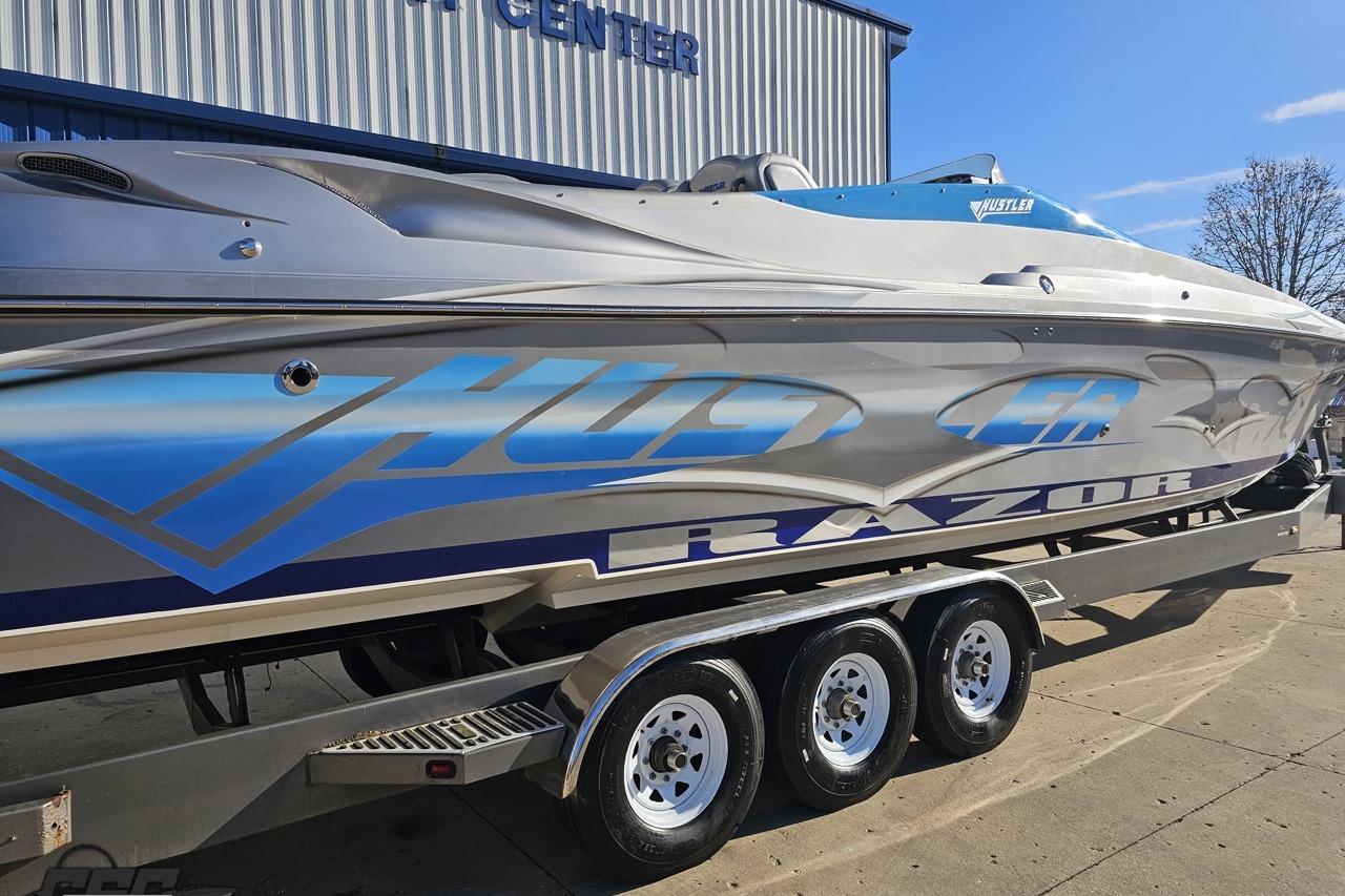 2007 Hustler 41 Razor speedboat on trailer, featuring sleek design and vibrant graphics.