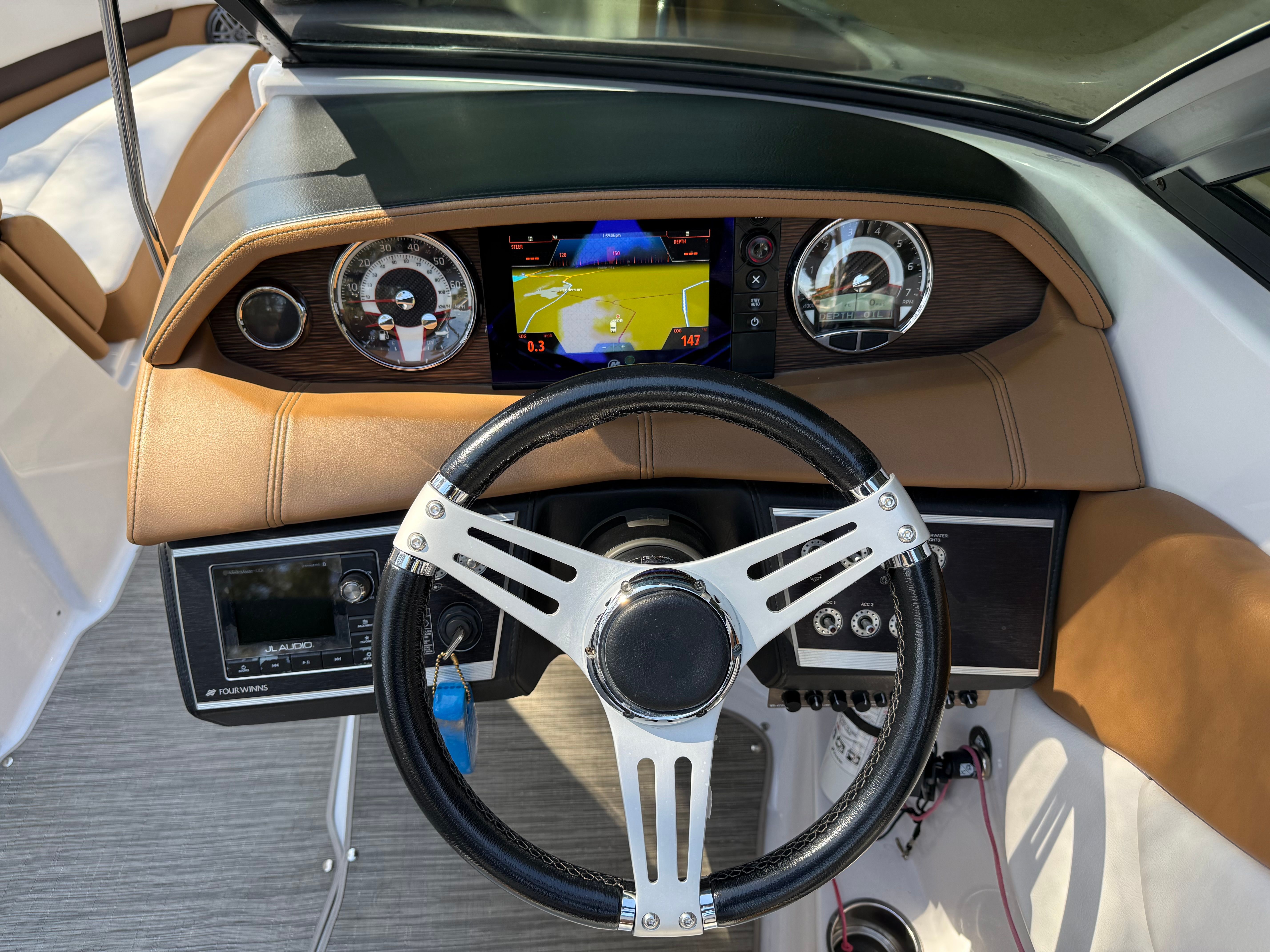 Dashboard of a 2019 Four Winns H260 boat with steering wheel and instruments.