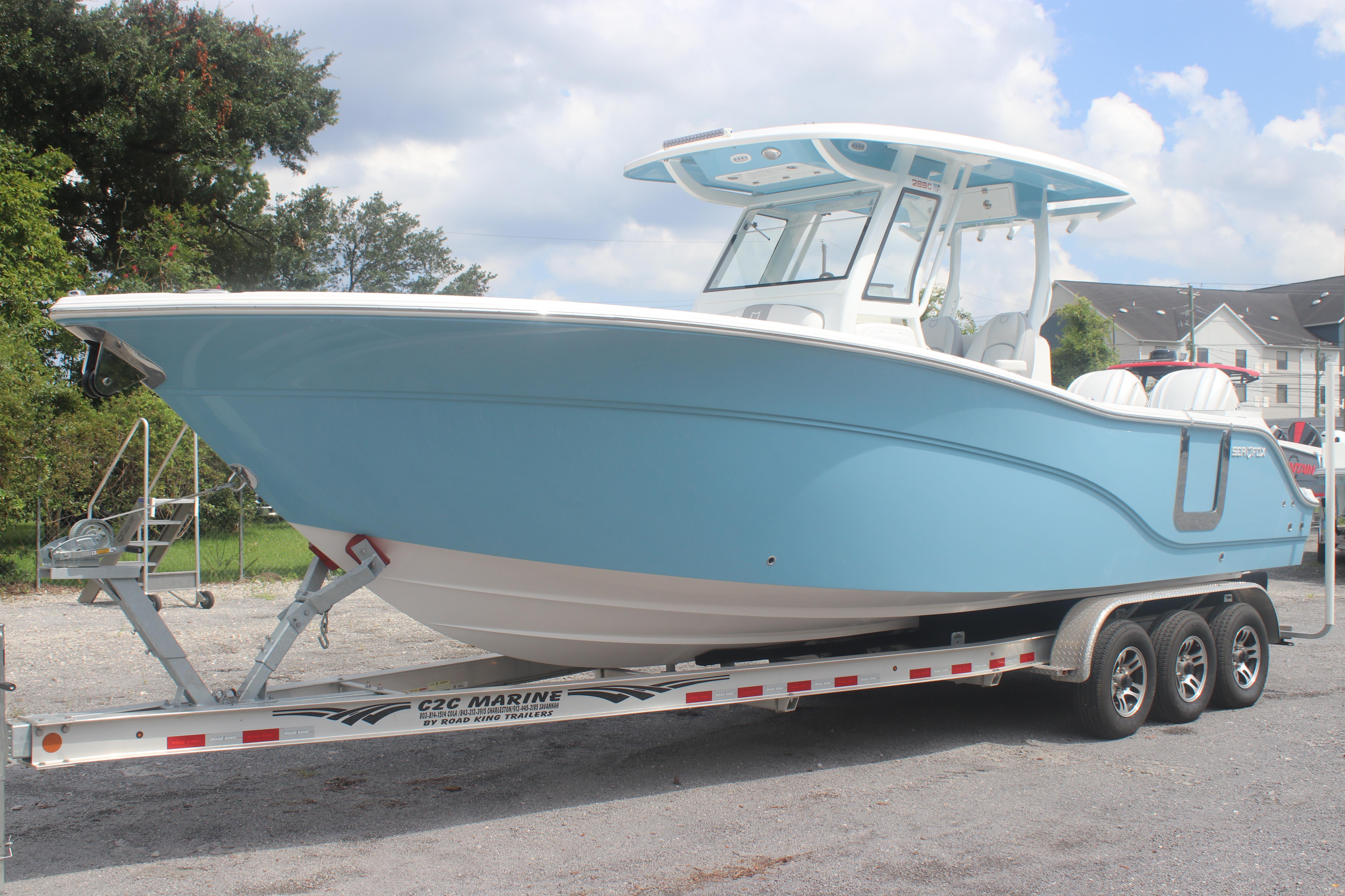 2026 Sea Fox 288 Commander boat on trailer, light blue hull, parked outdoors.