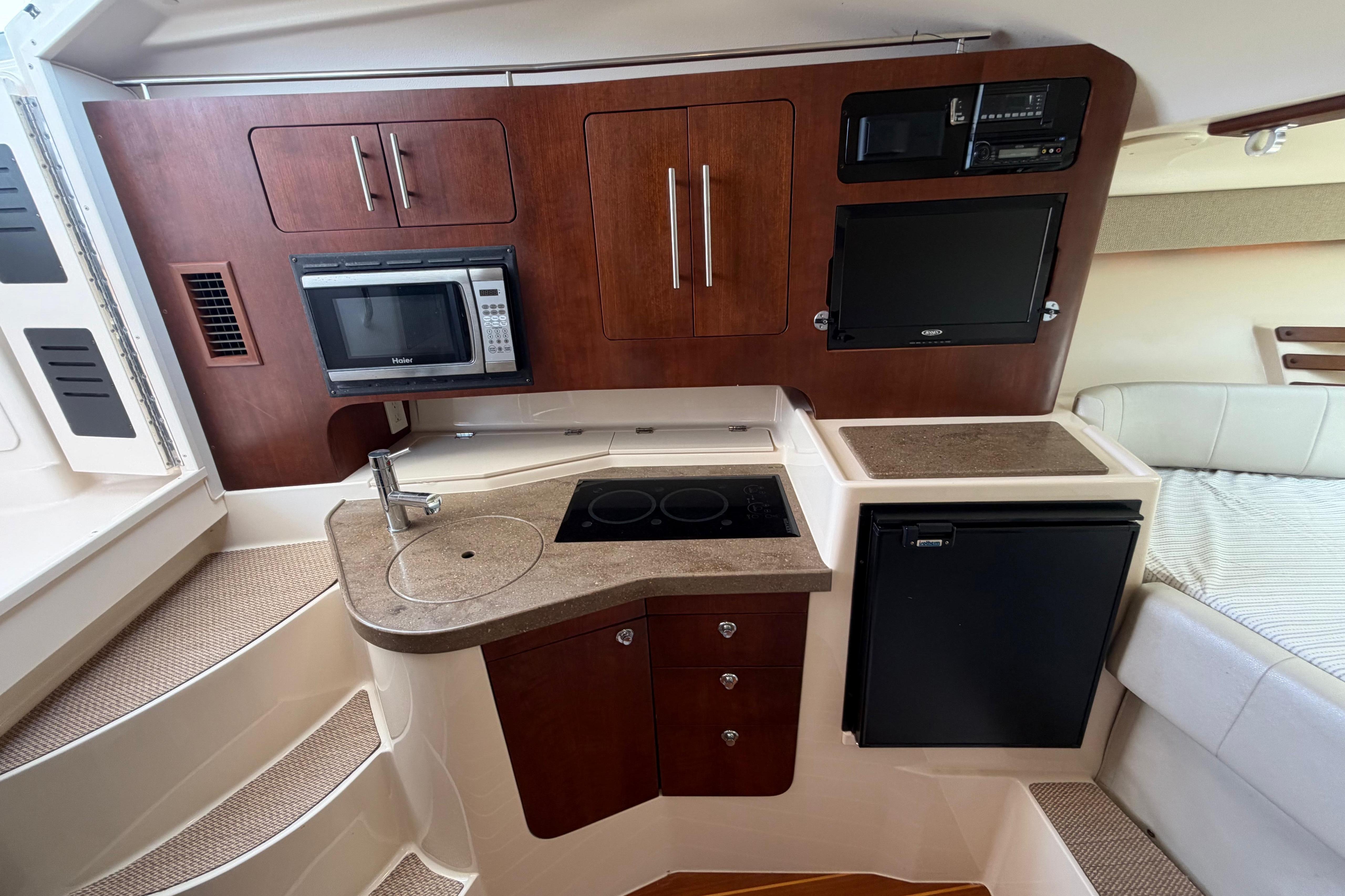 2014 Grady-White Express 330 boat interior with kitchenette, microwave, and compact fridge.