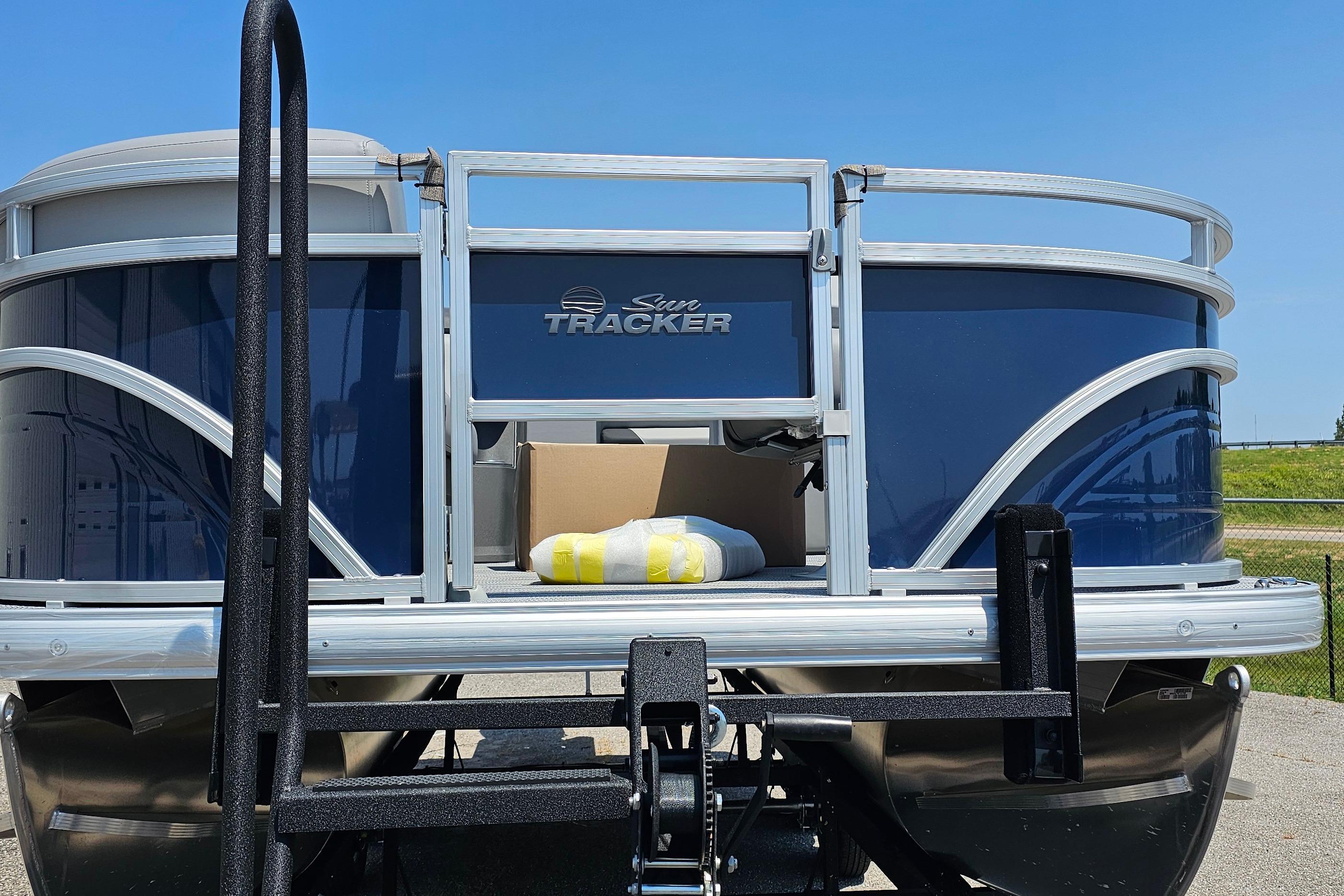 2026 Sun Tracker SportFish 20 DLX pontoon boat, blue exterior, docked outdoors.