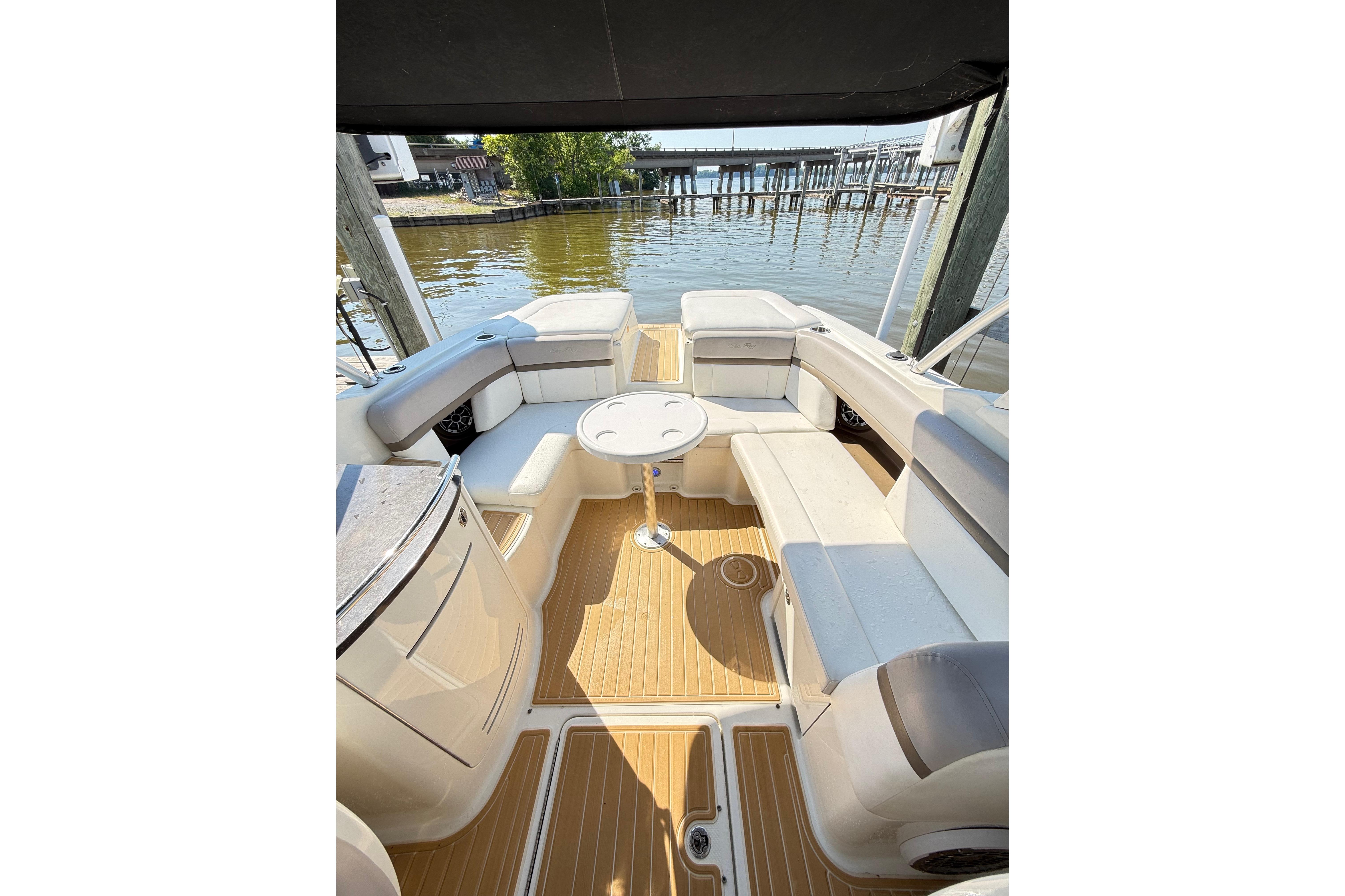Spacious seating area on a 2011 Sea Ray 270 SLX boat docked by the water.