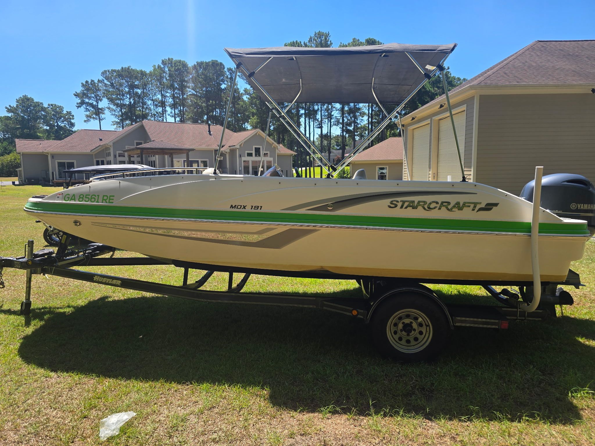 A 2017 Starcraft MDX 191 OB boat on a trailer, parked on grass.