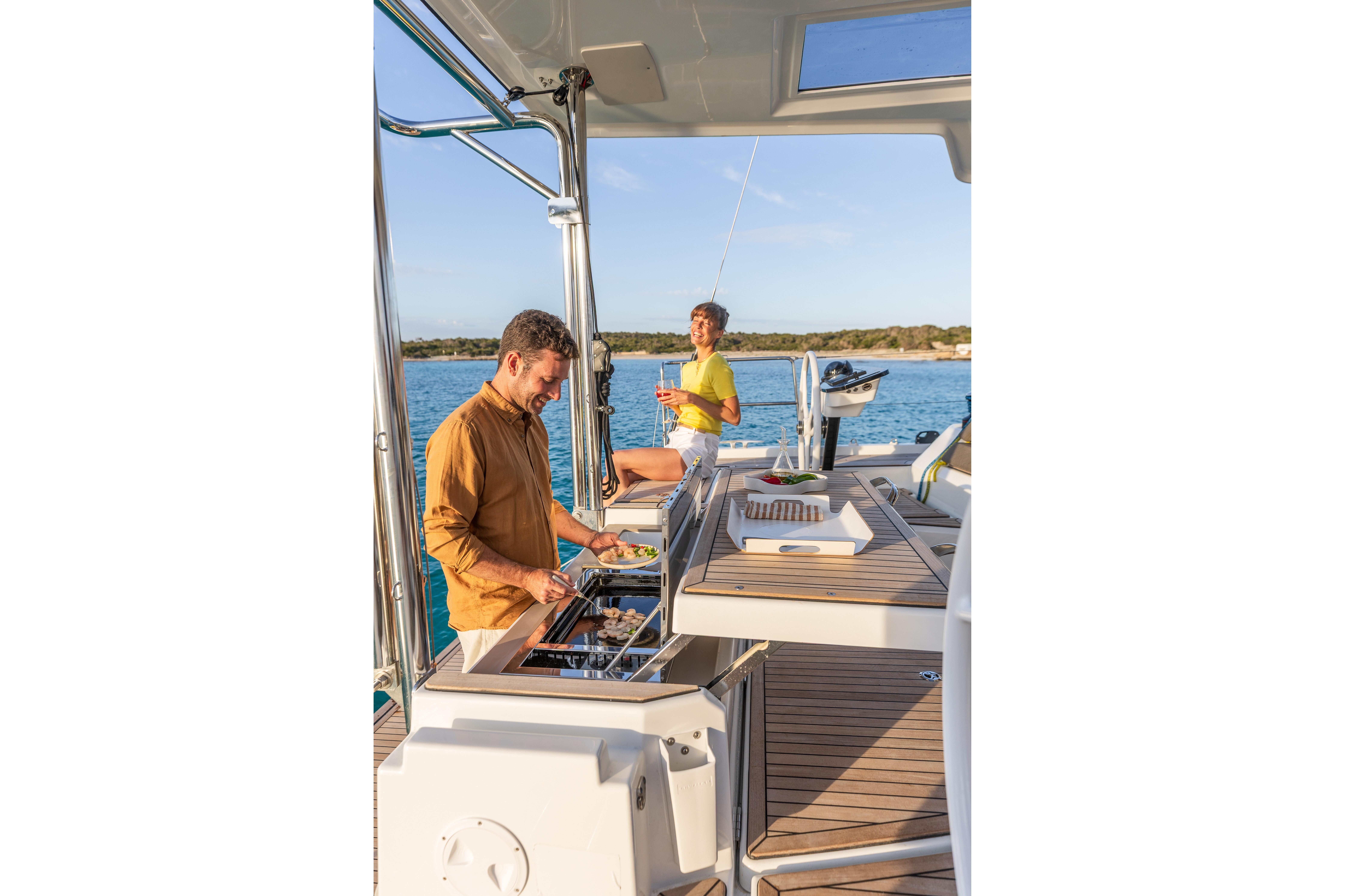 Two people enjoying a meal on a 2025 Dufour 48 yacht deck.
