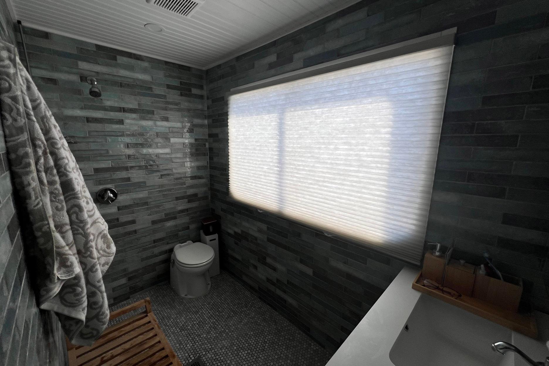 Bathroom interior of a 1993 Sumerset houseboat with modern gray tile design.