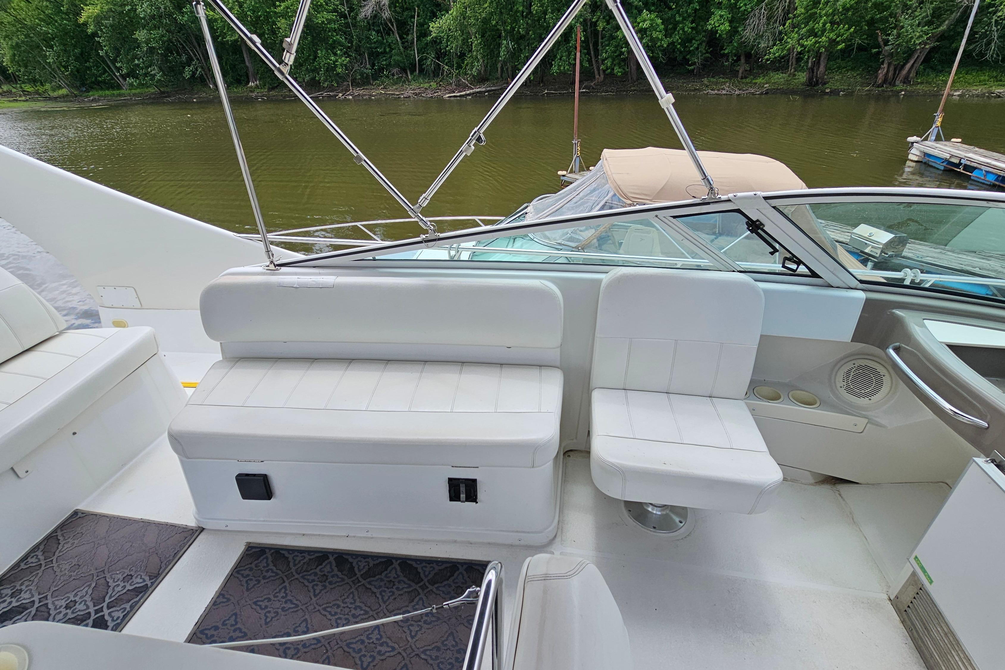 1999 Carver 350 Mariner boat interior with white seating, docked by a river.