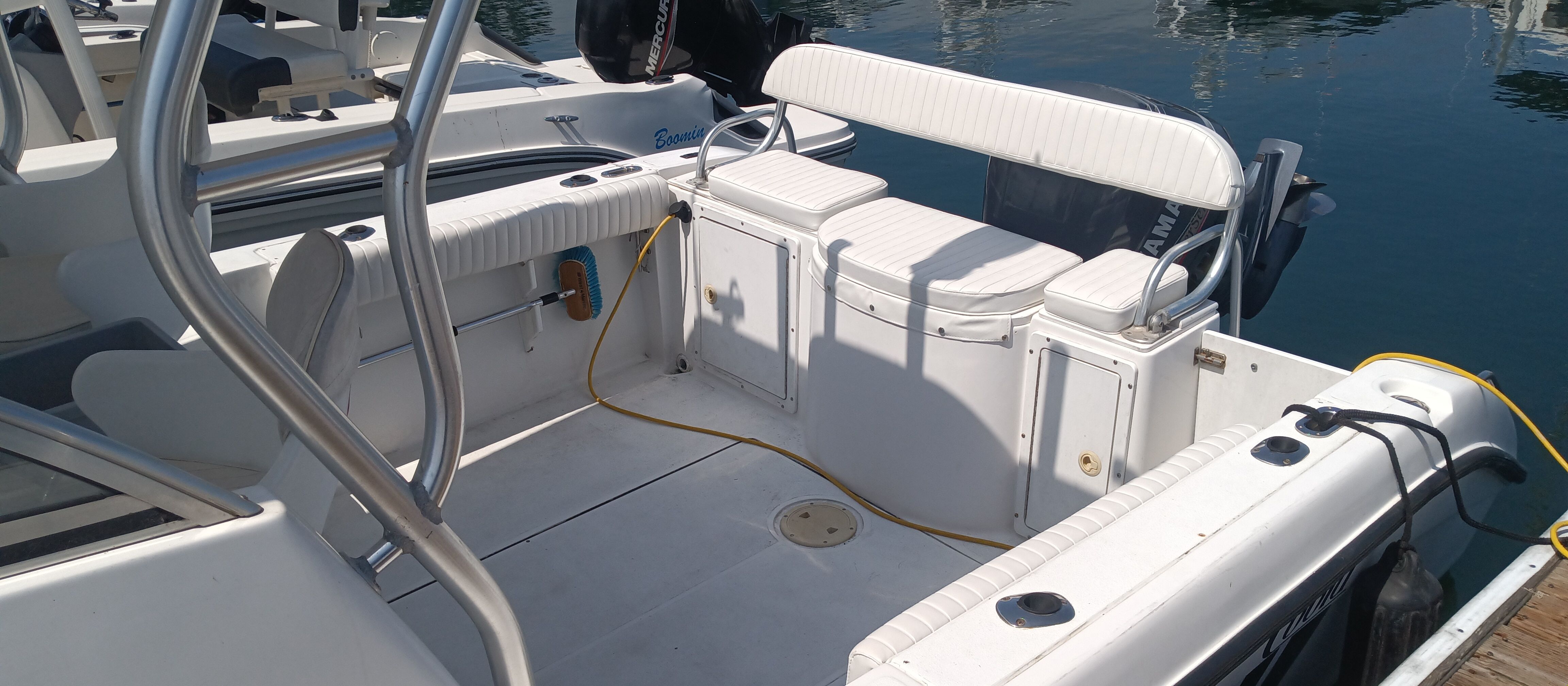 The image shows the cockpit of a 1999 Cobia Walkaround boat with white seating.