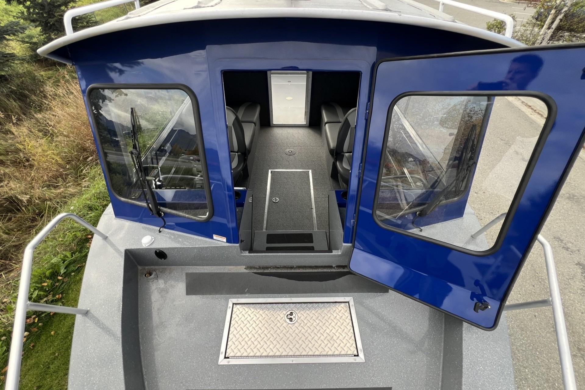 2024 Spartan 26 Maximus Pro XL boat with open cabin doors and interior view.