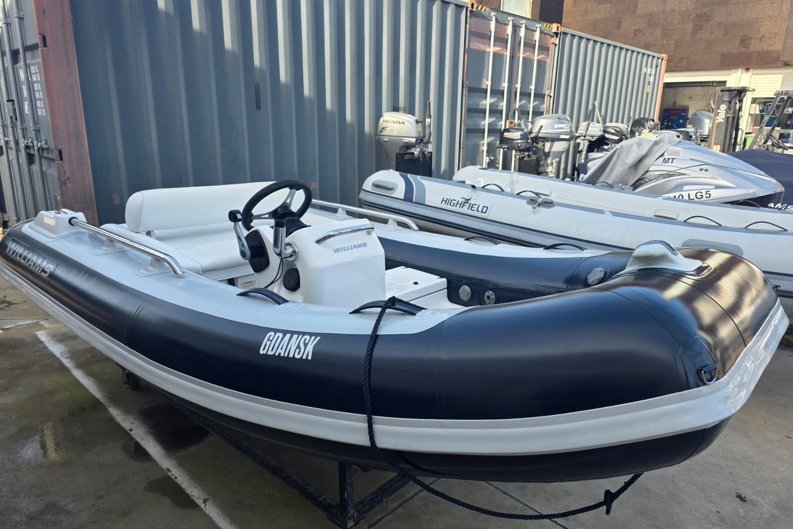 2021 Williams Jet Tenders Sportjet 345 inflatable boat docked near shipping containers.