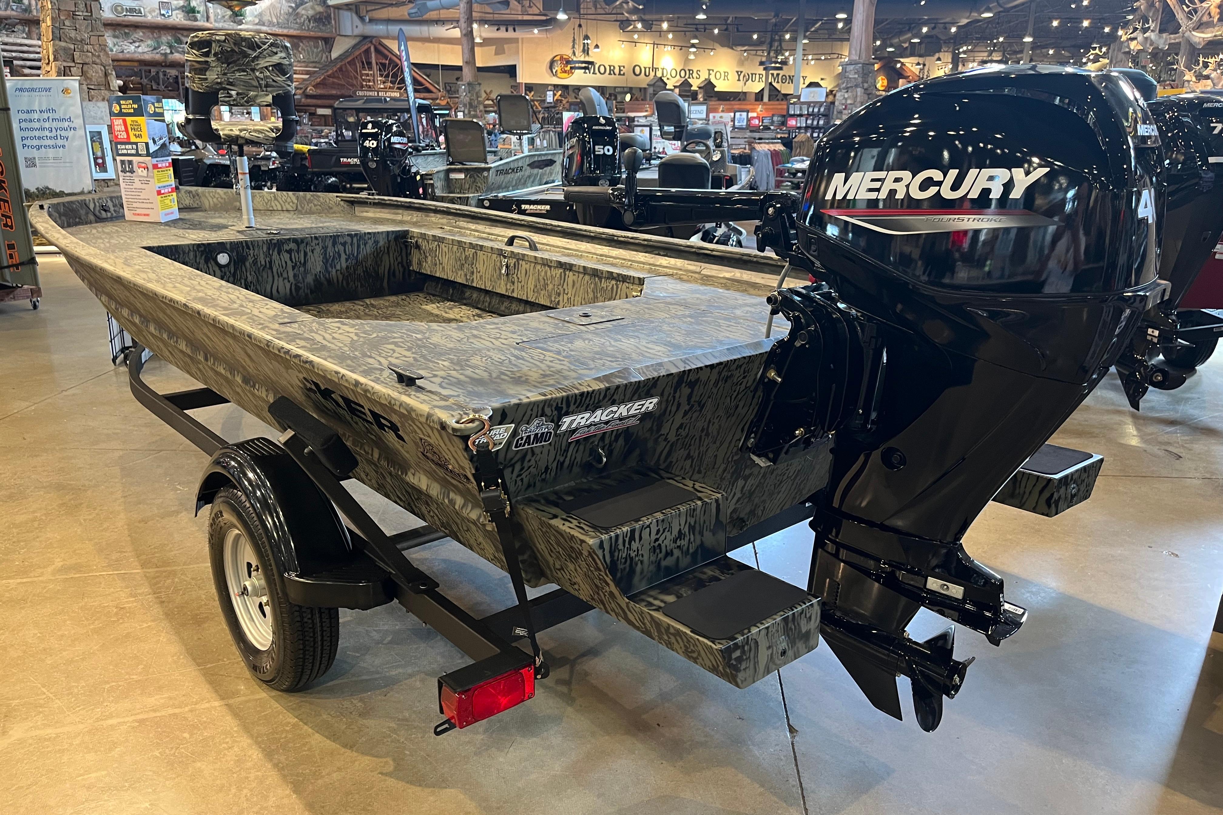 2026 Tracker Grizzly 1654 T Sportsman boat with Mercury outboard motor in showroom.
