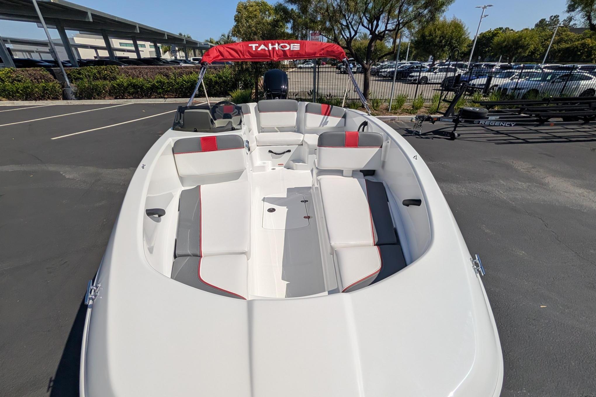 2026 Tahoe T16 boat with red and gray seating, parked outdoors.