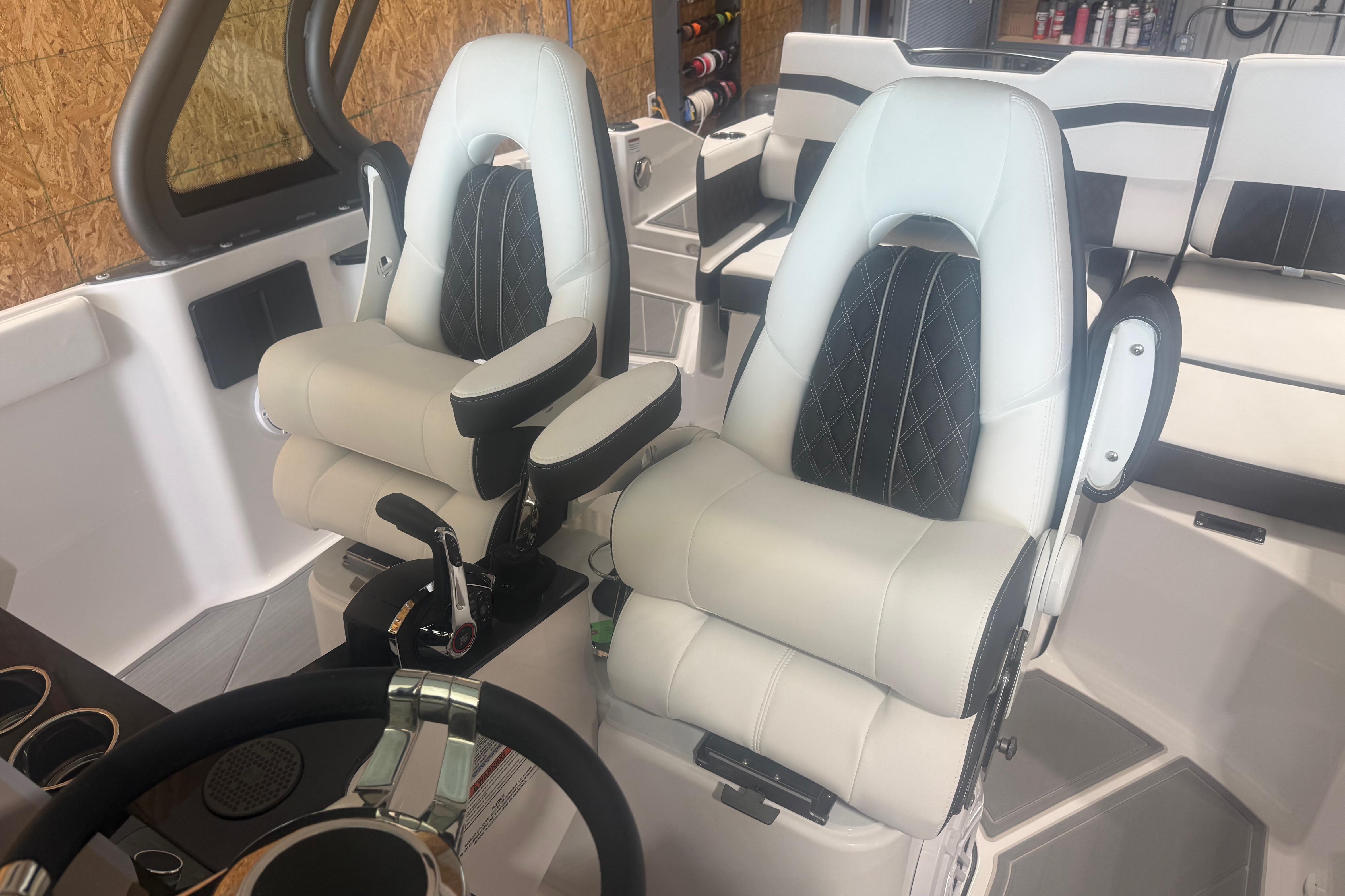 Luxury seating in 2027 Monterey Elite 27 SD boat cockpit, featuring plush white upholstery.