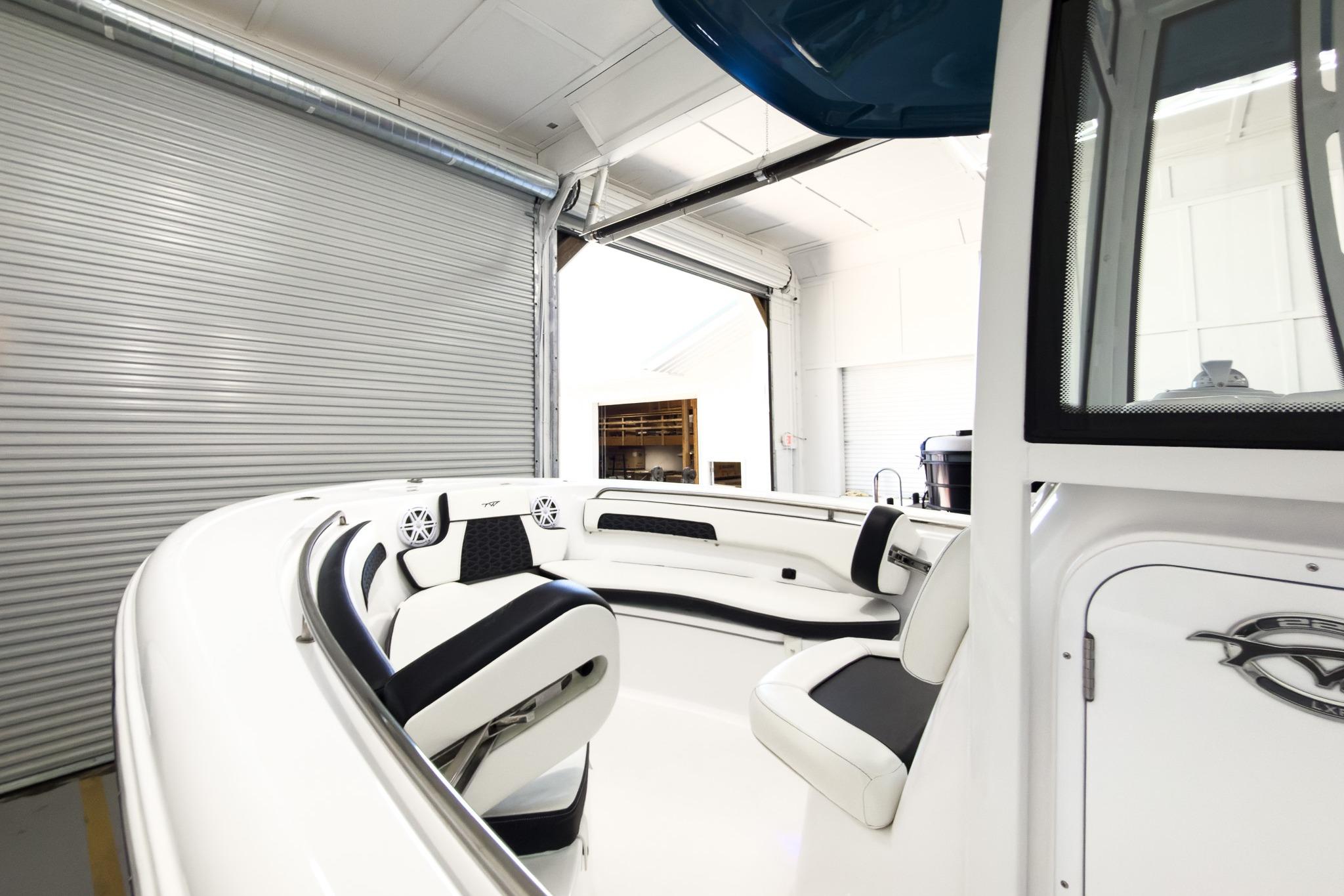 Interior view of a modern boat with white and black seating in a garage.