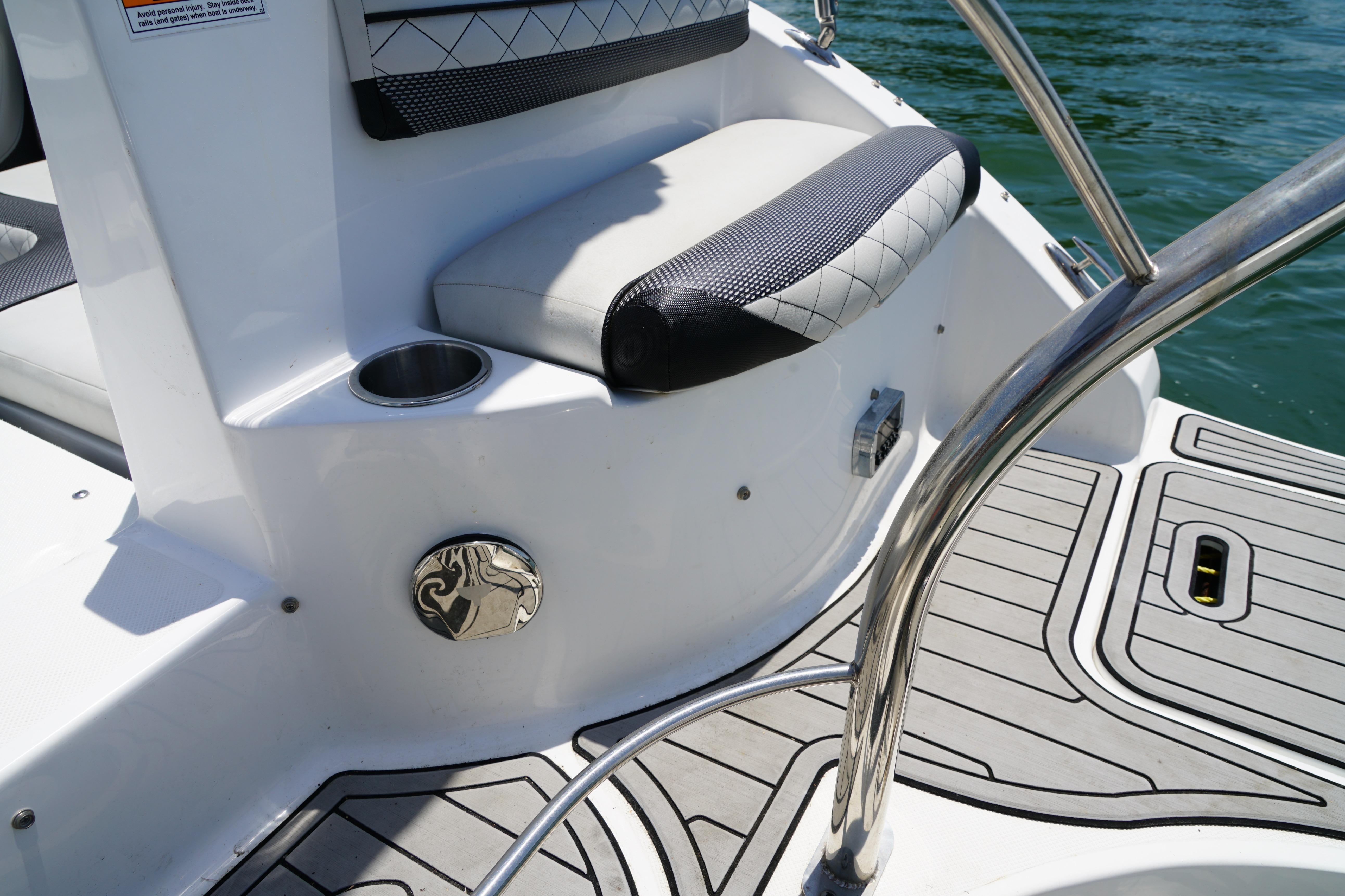 2020 Hurricane SunDeck 2486 OB boat interior with cushioned seating and stainless steel railing.