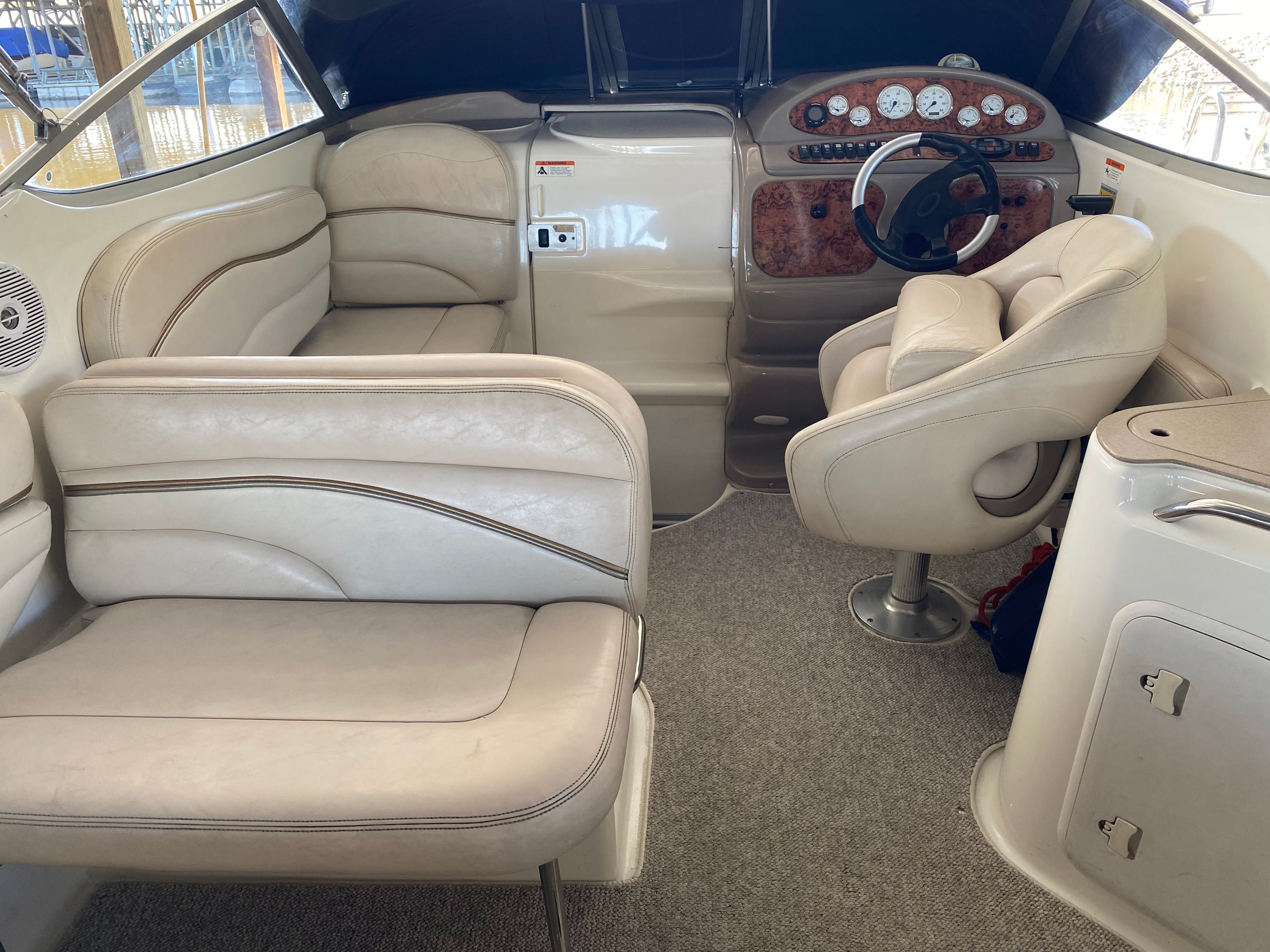 Interior of a 2005 Larson Cabrio 240 with beige seating and a sleek dashboard.