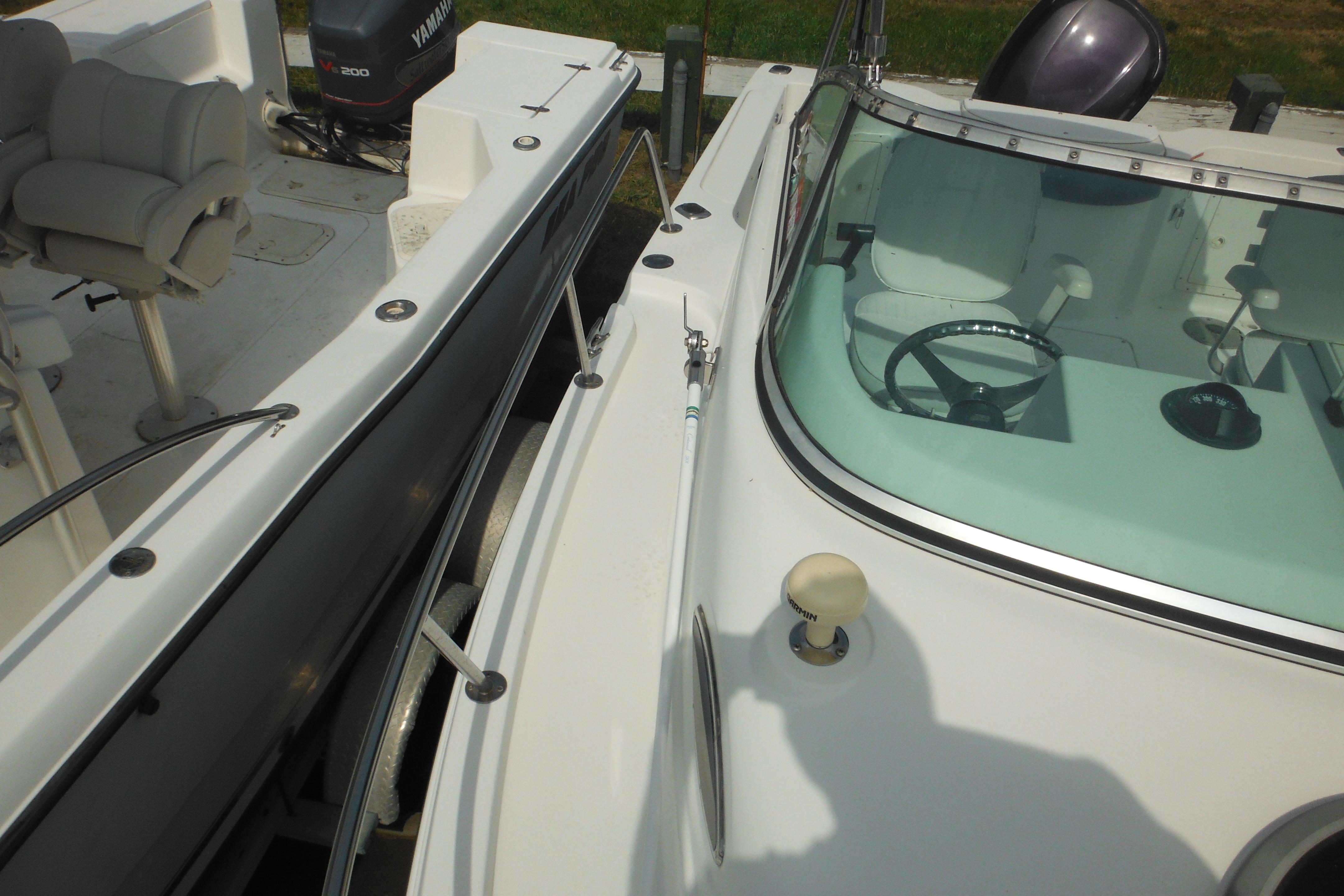 2005 Seaswirl Striper 2101 Walkaround O/B boat with Yamaha engine, docked side by side.