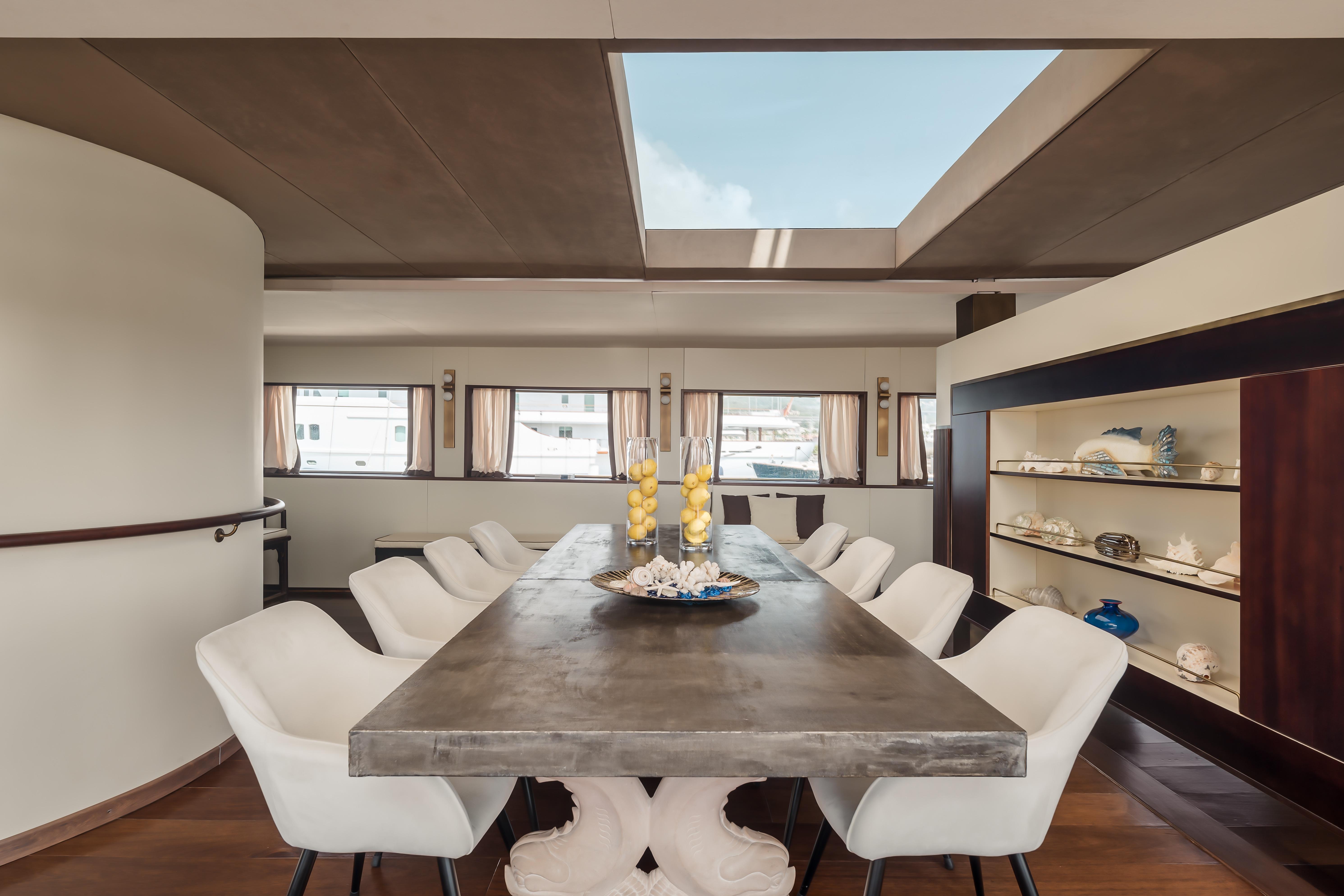 Luxurious dining area on a 1956 custom converted tugboat with elegant decor and large windows.