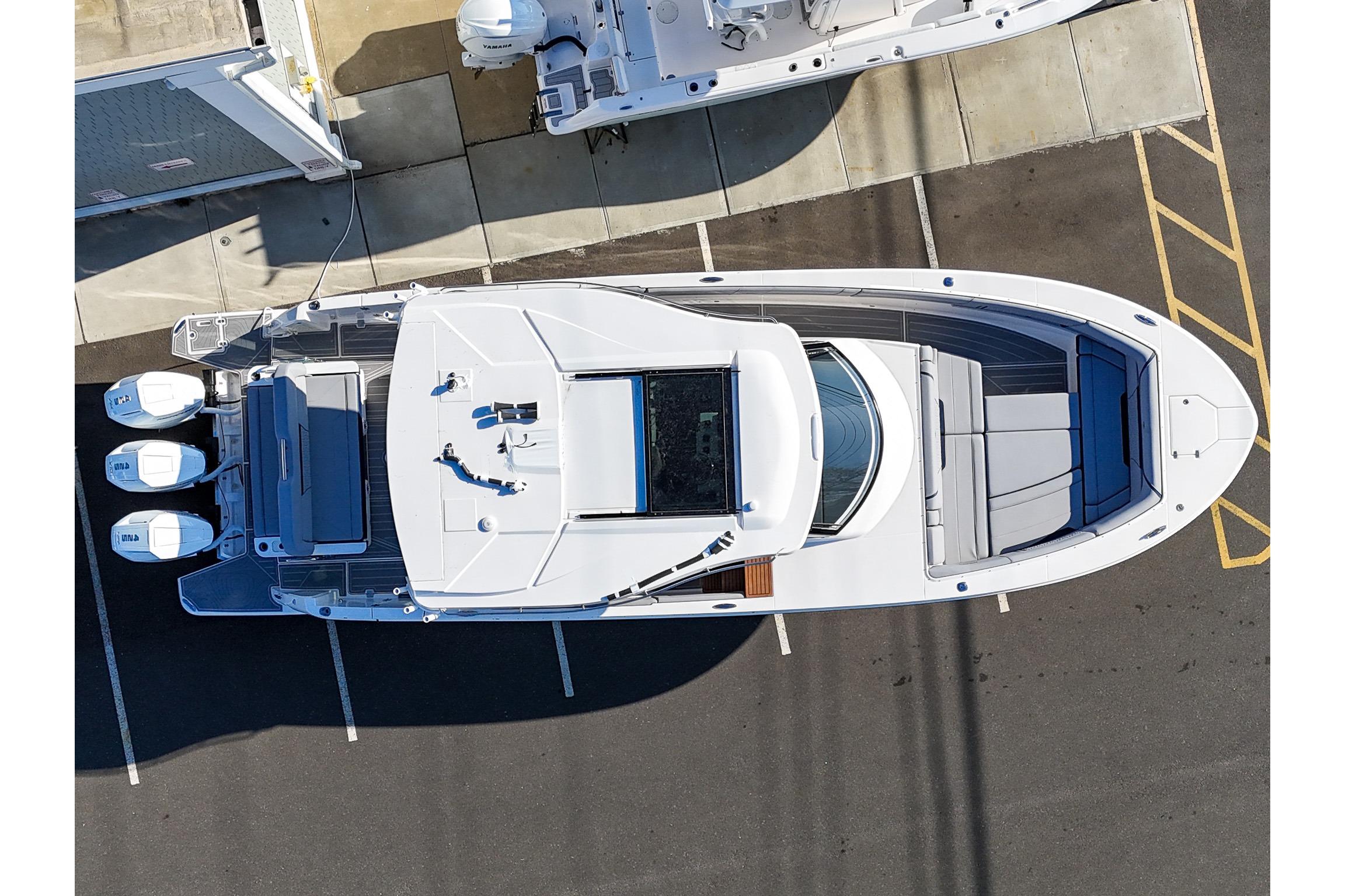 Aerial view of a 2026 Regal 38 SAV boat docked, showcasing sleek design and triple engines.