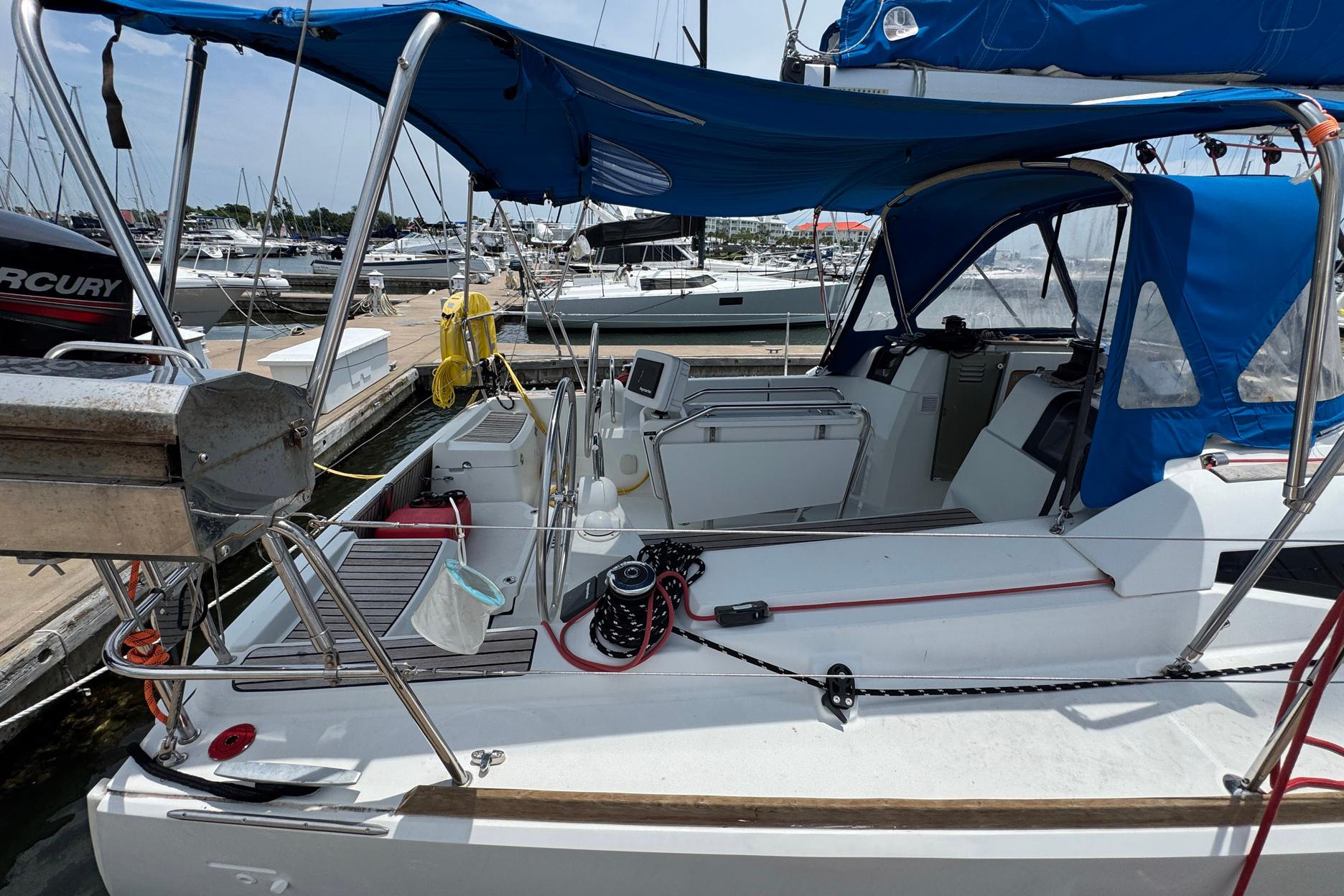 2018 Jeanneau Sun Odyssey 389 sailboat docked, featuring blue canopy and modern cockpit design.