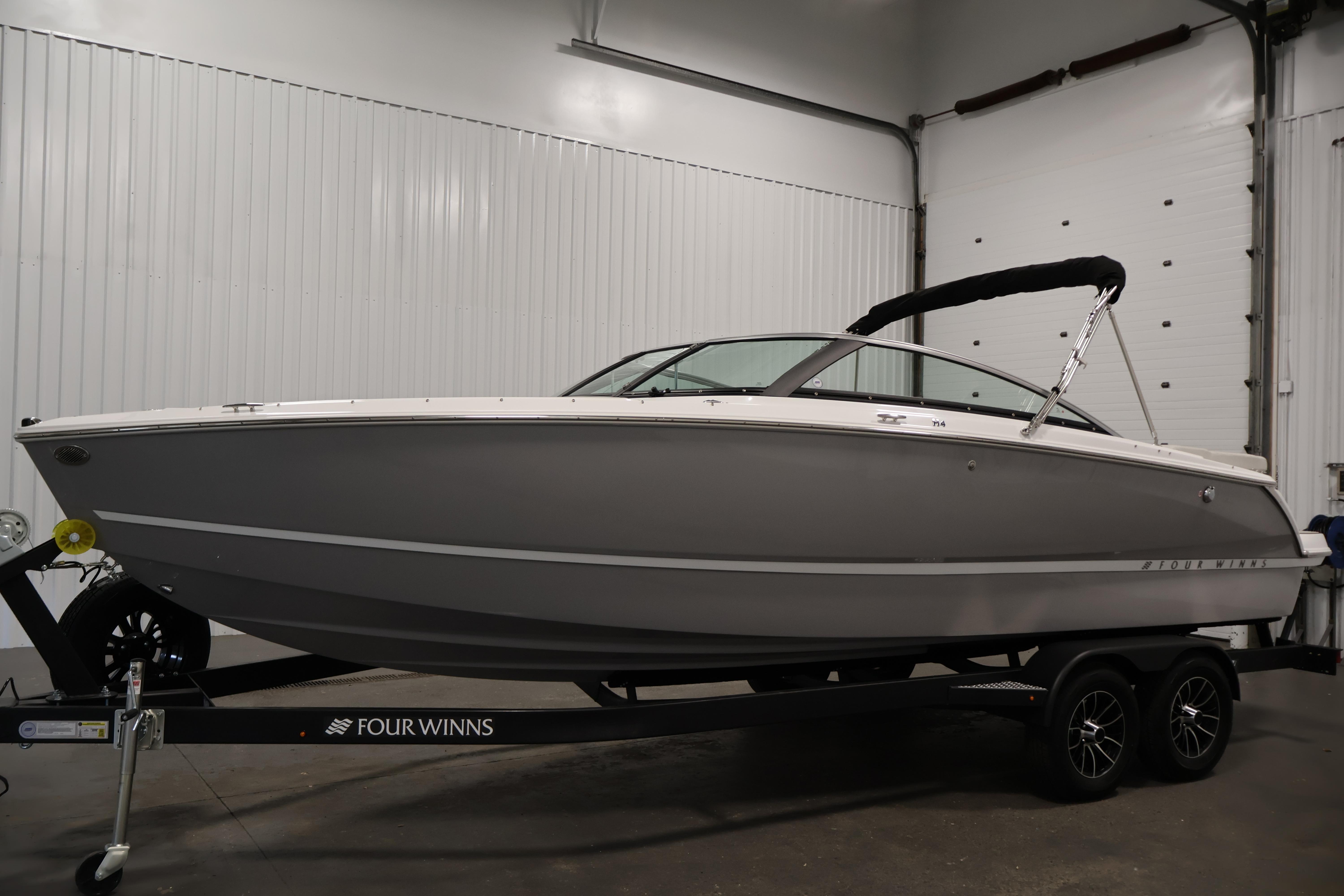 2026 Four Winns H4 Freedom boat on trailer in indoor showroom.