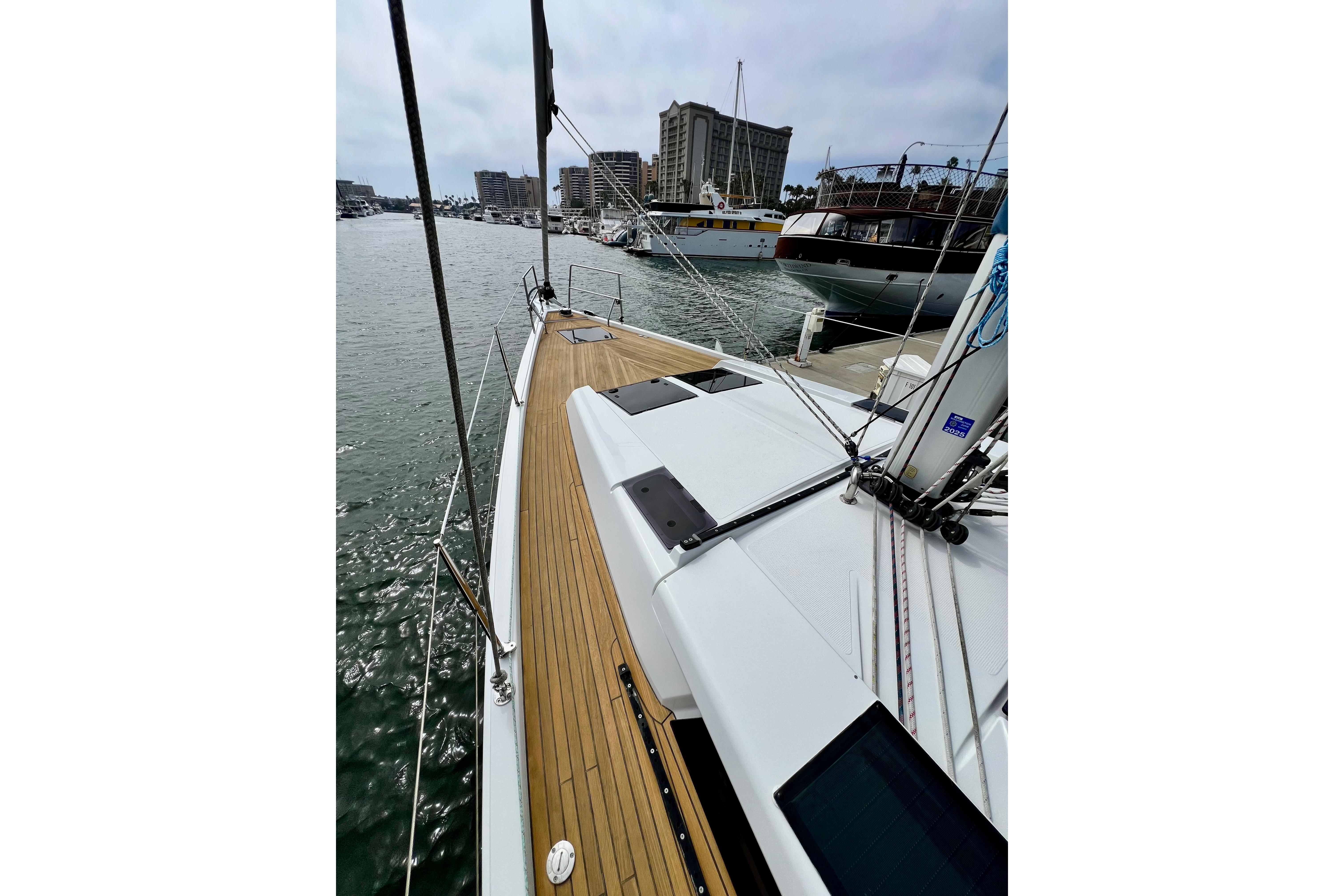 2016 Hanse 455 sailboat docked in marina, showcasing sleek deck design and urban skyline.