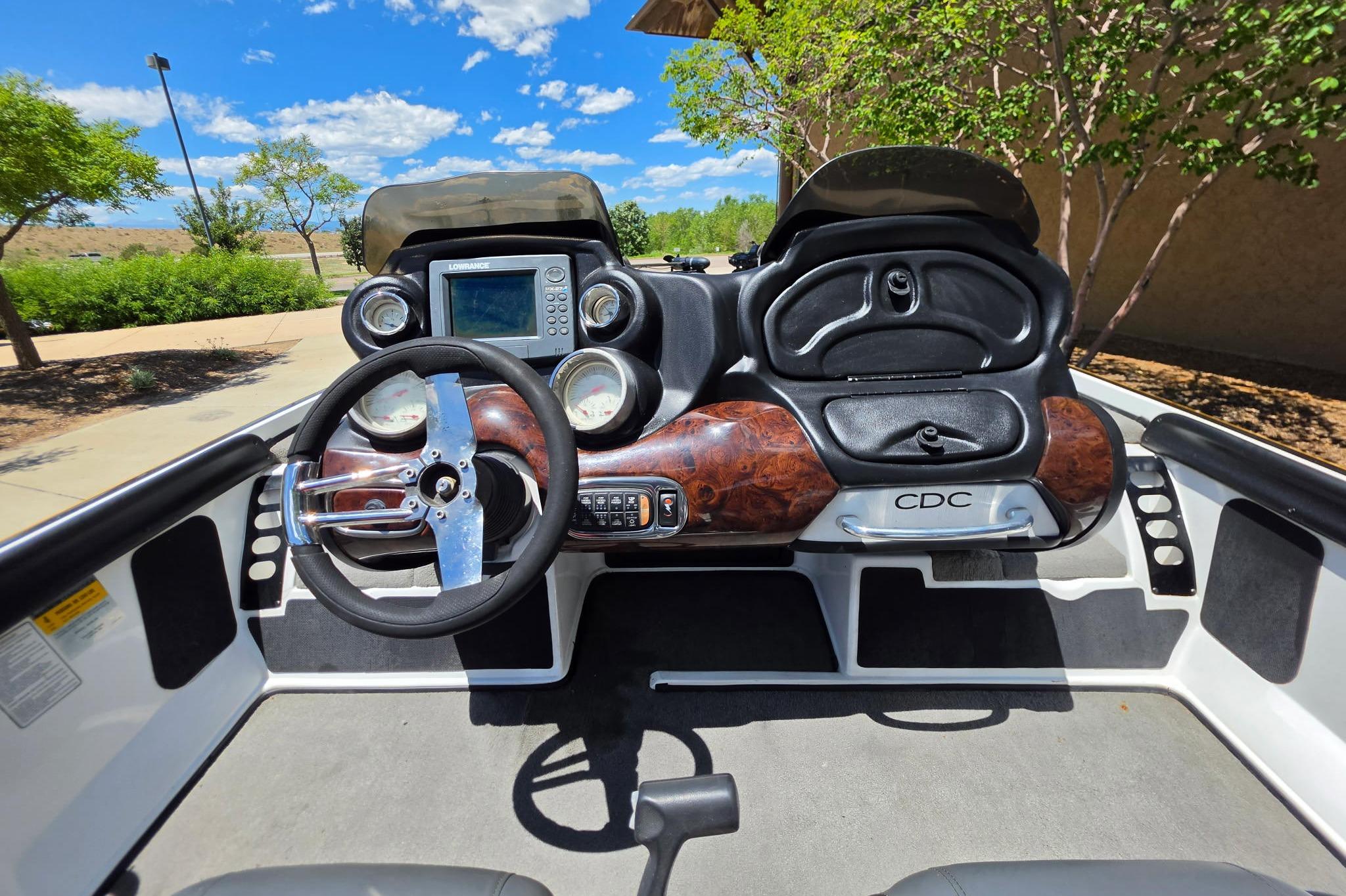 2008 Nitro Z-9 boat dashboard with steering wheel and navigation system under a clear blue sky.