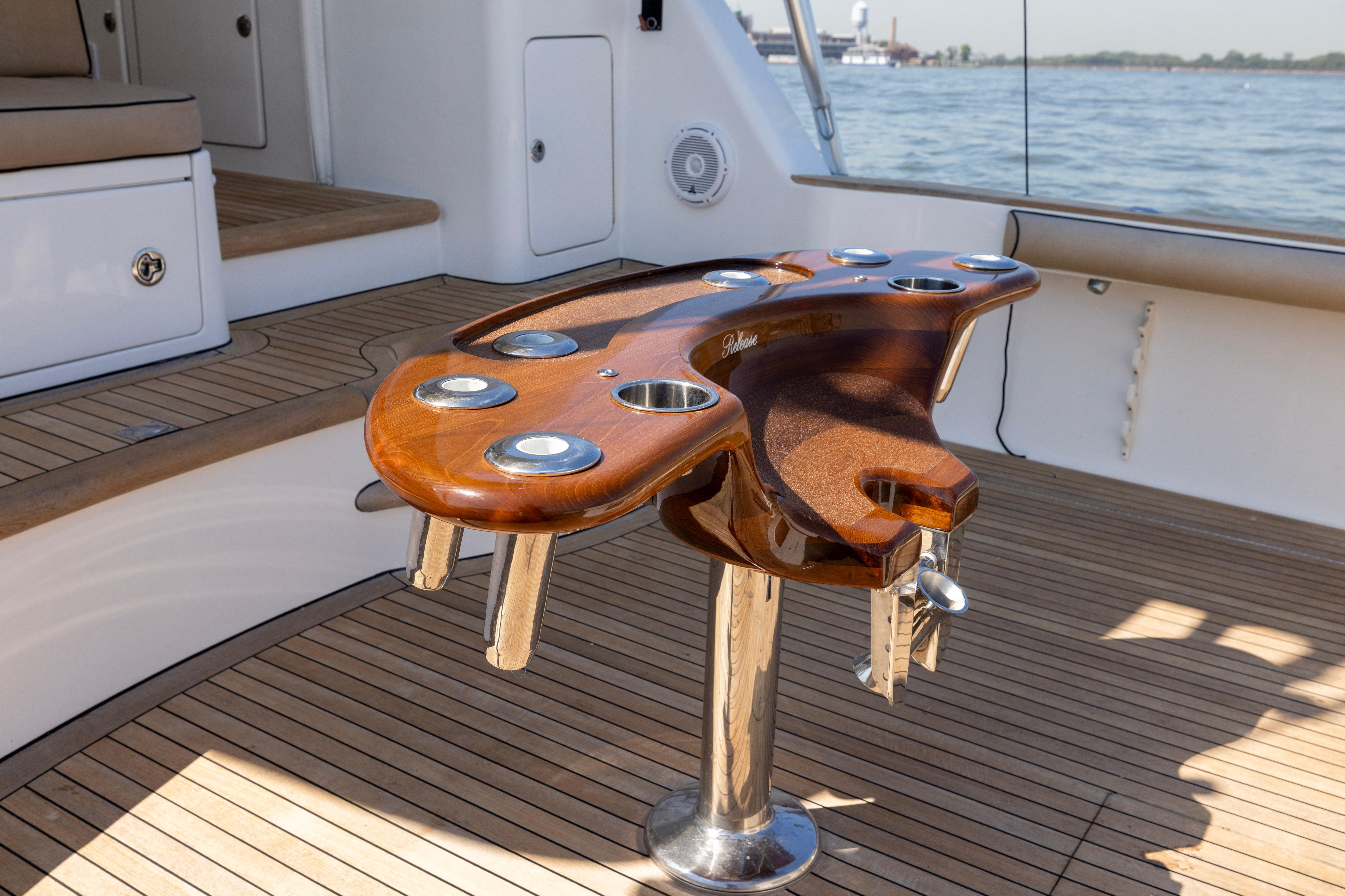 Luxurious 2012 Cabo 44 Hardtop Express yacht with elegant wooden deck and fishing rod holders.