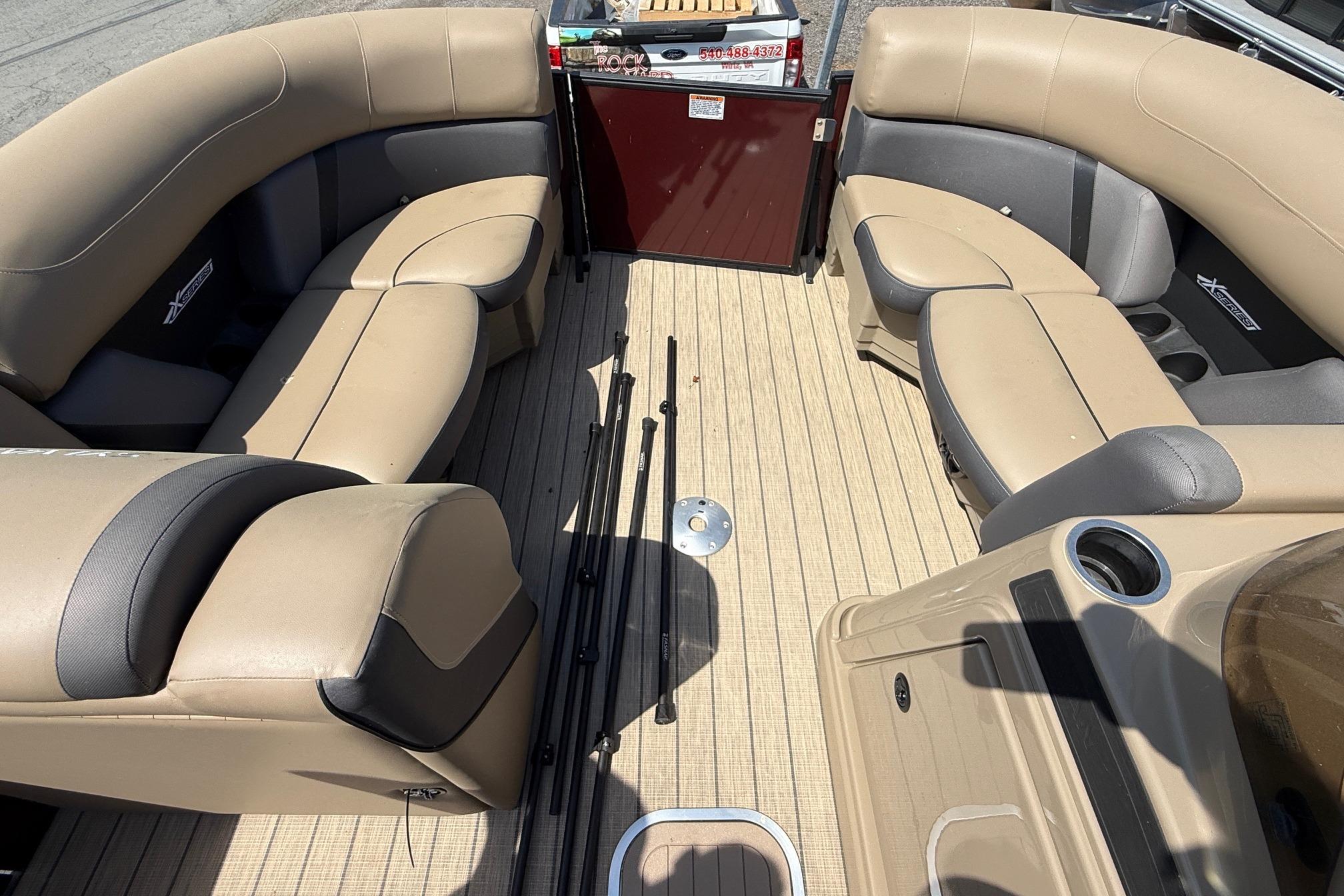 Interior of 2024 Sylvan X1 CLZ DH pontoon boat with beige seating and wood flooring.