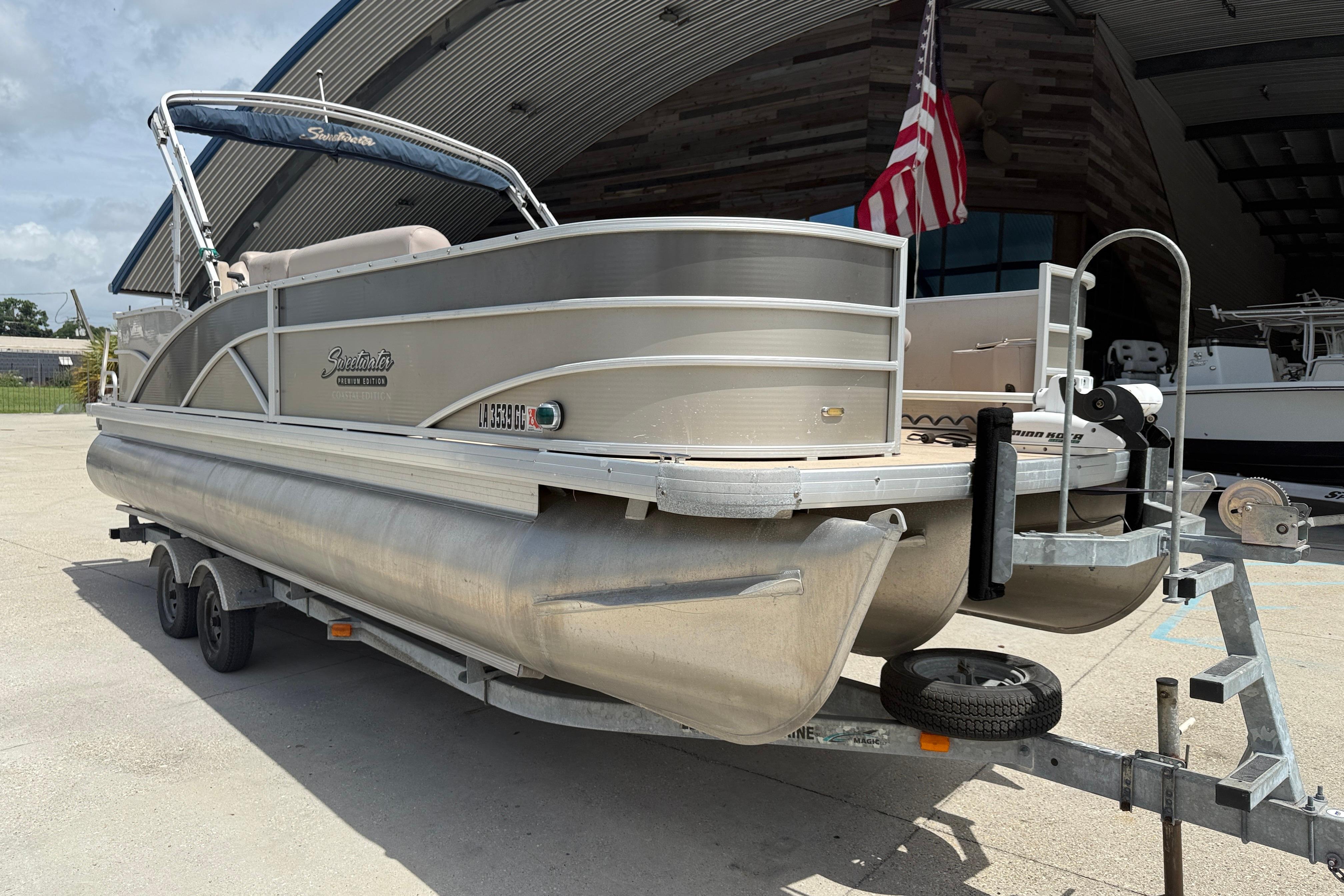 2014 Godfrey Sweetwater 2486 C pontoon boat on trailer, parked outdoors.