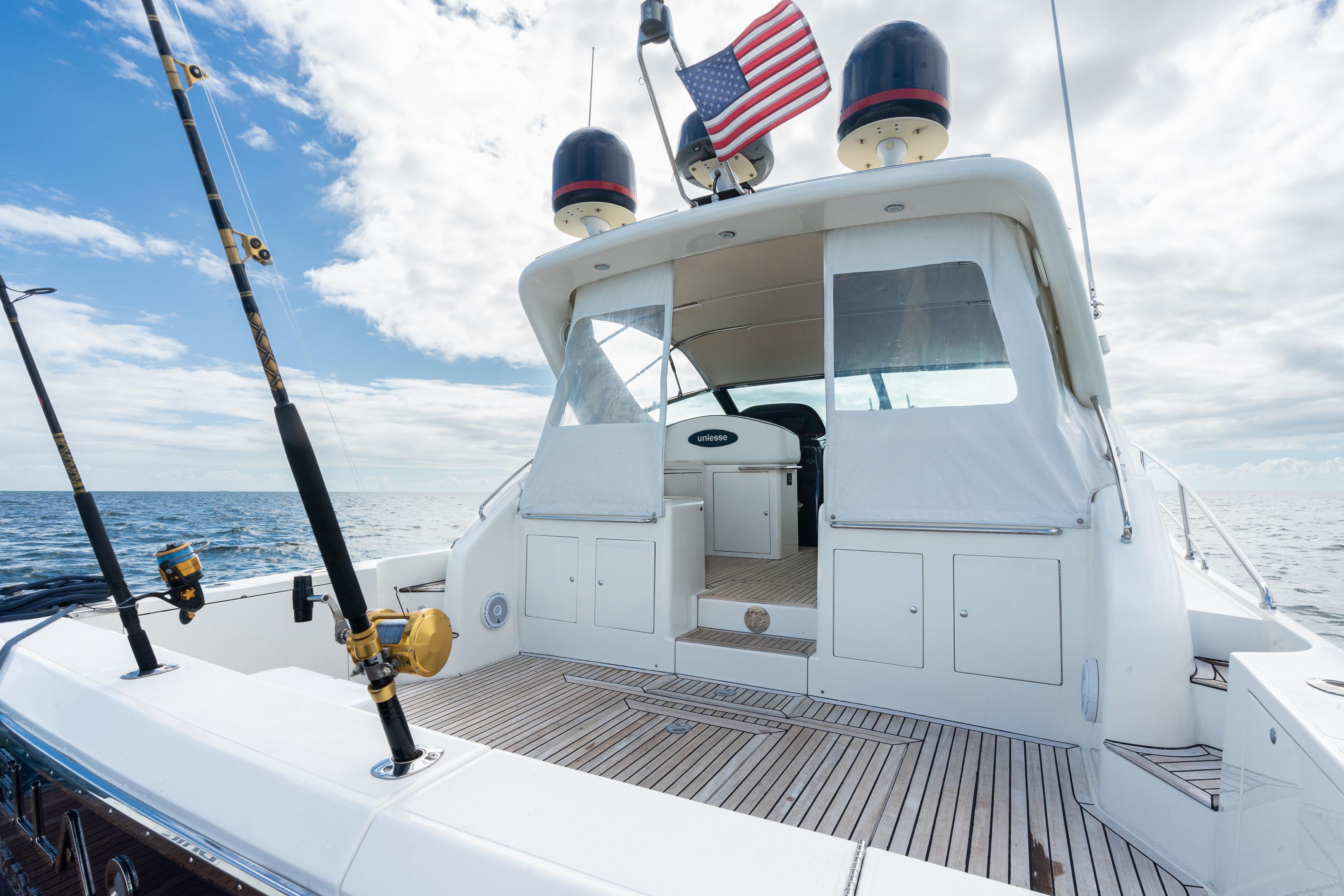 2001 Uniesse 48 Open yacht with fishing rods and American flag on deck.