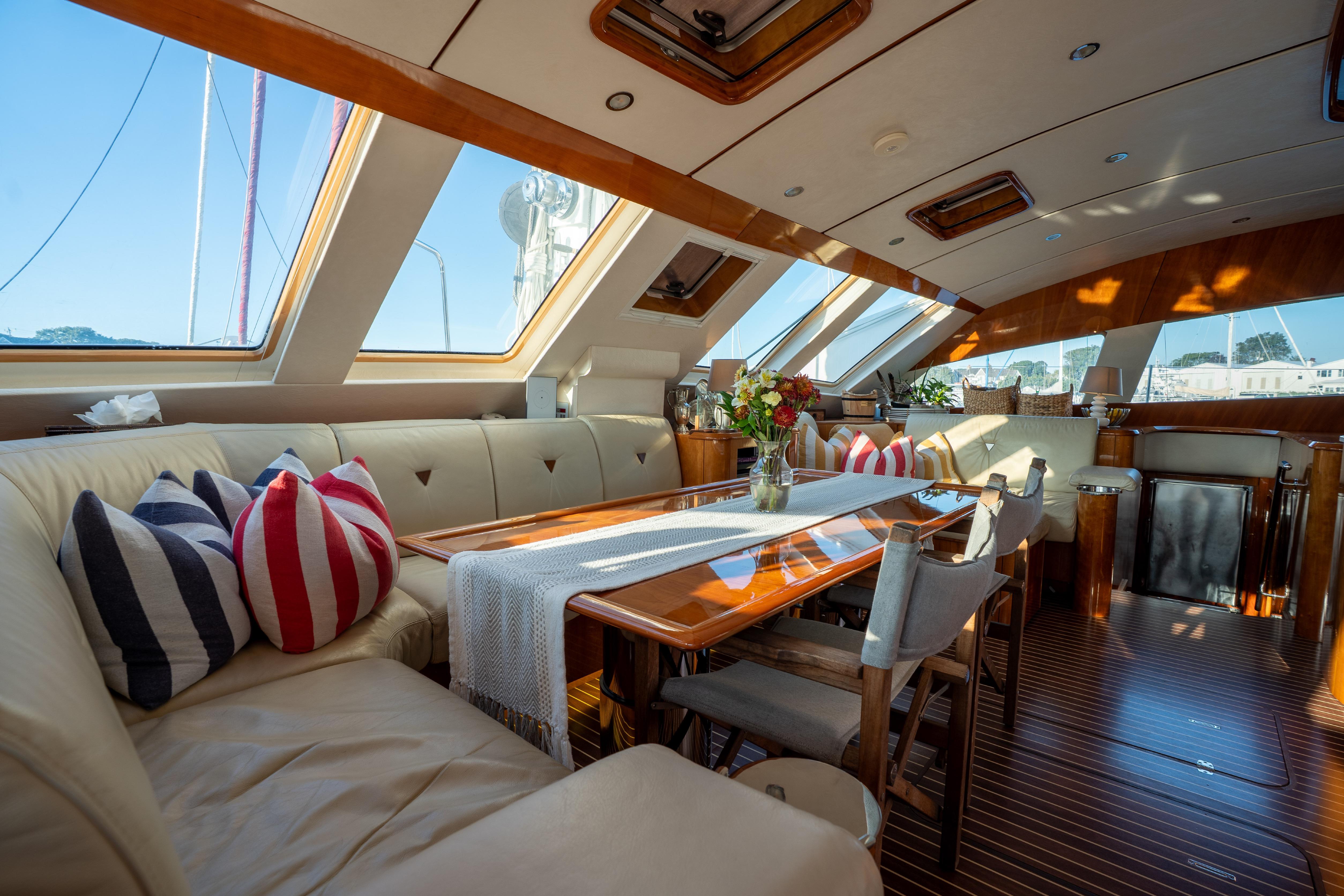 Luxurious 2009 Privilege 615 yacht interior with elegant seating, striped cushions, and panoramic windows.