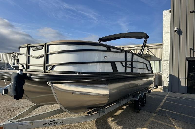 2026 Evotti 523CS pontoon boat on trailer, parked outside industrial building.