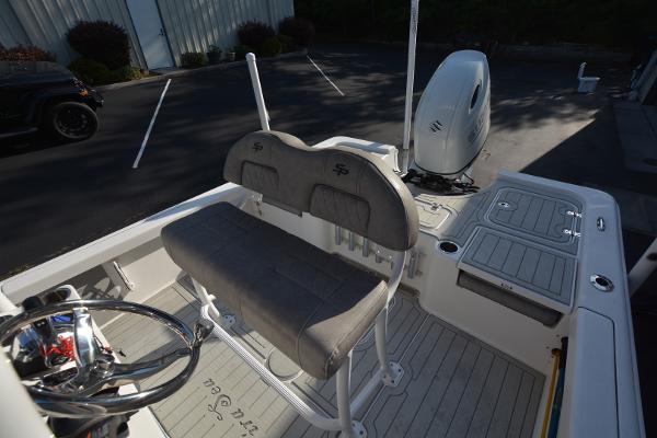 2021 Sea Pro 228 Bay boat interior with seating and motor in a parking lot.