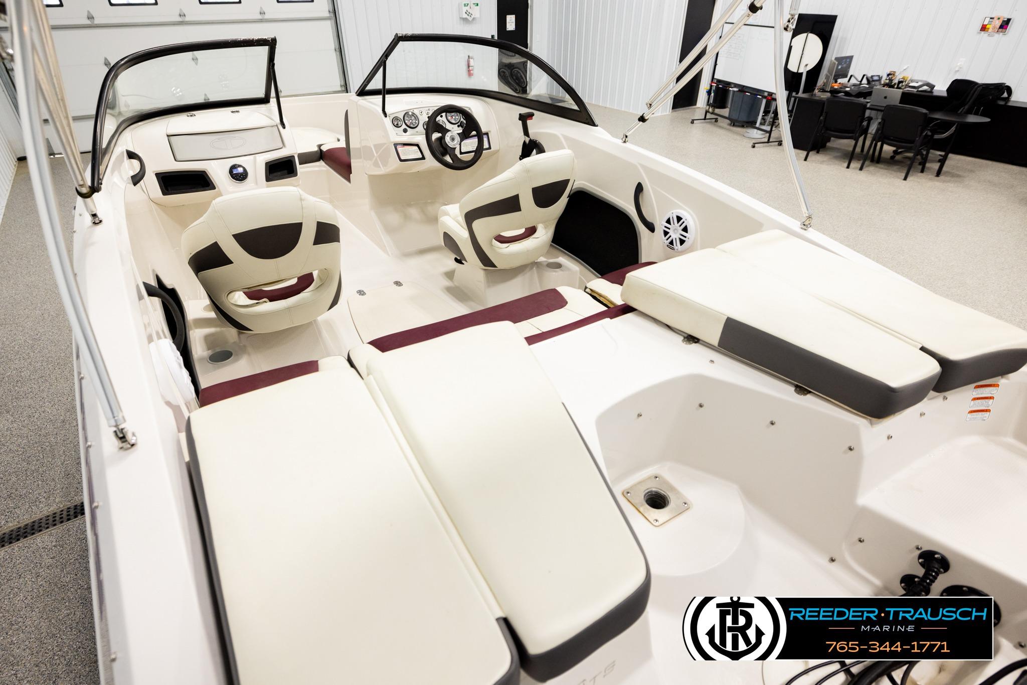 2016 Tahoe 450 TS boat interior with seating and steering wheel in showroom.