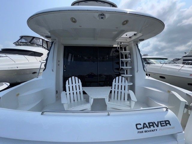 2002 Carver 570 Voyager Pilothouse yacht docked at marina.