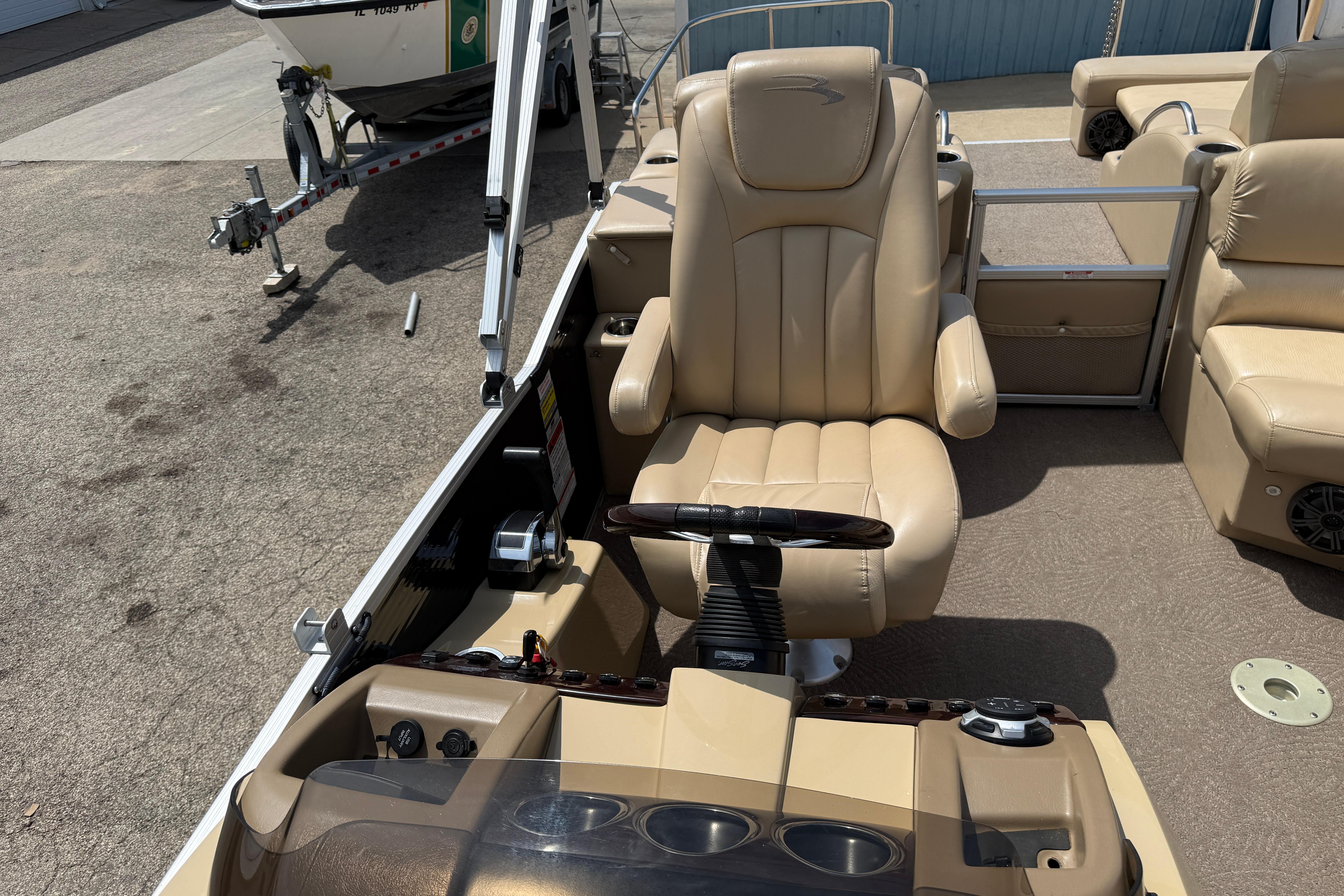 Captain's chair and helm of a 2011 Bennington 2575QCW I/O boat.