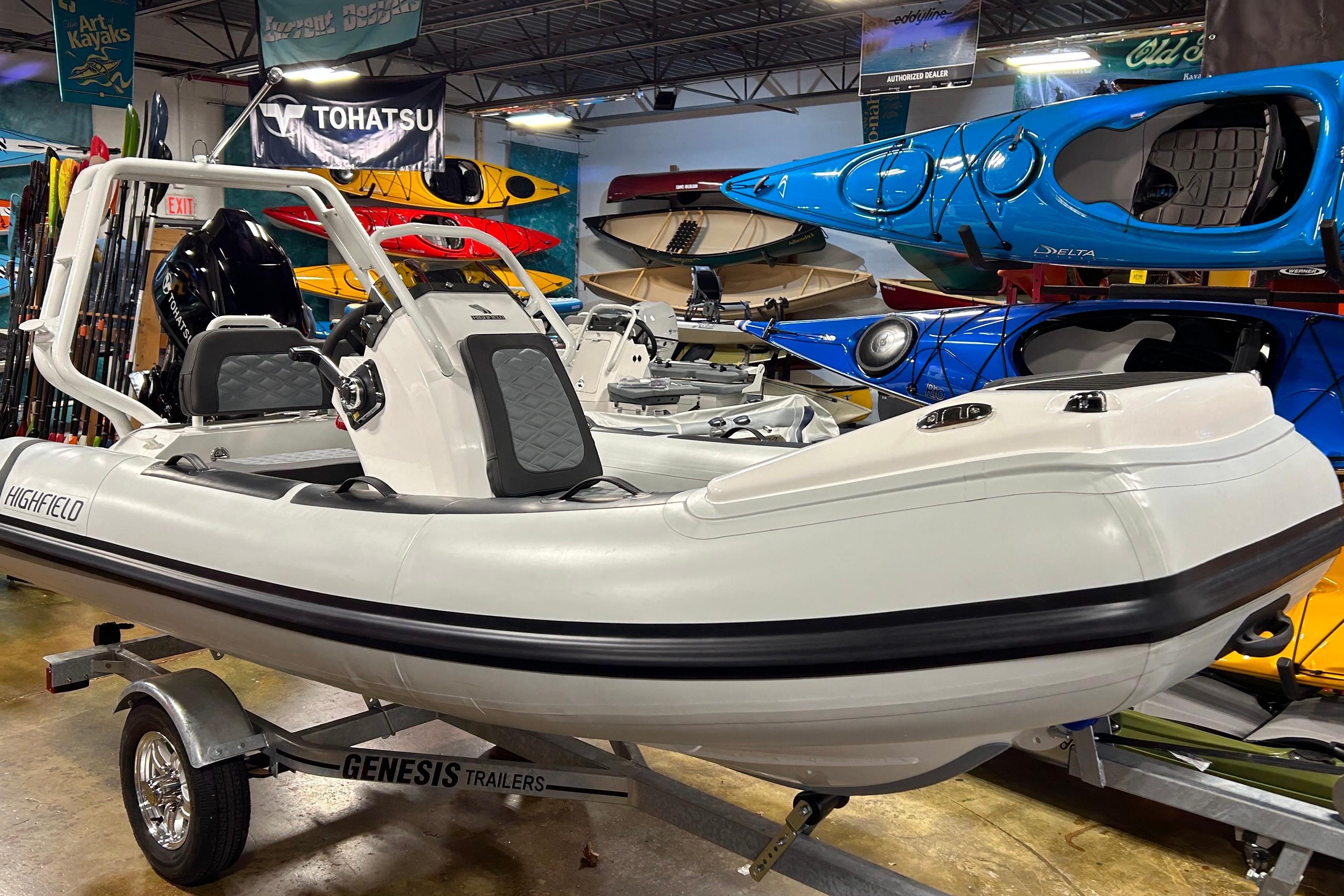 2026 Highfield Sport 390 boat on Genesis trailer in showroom with kayaks.