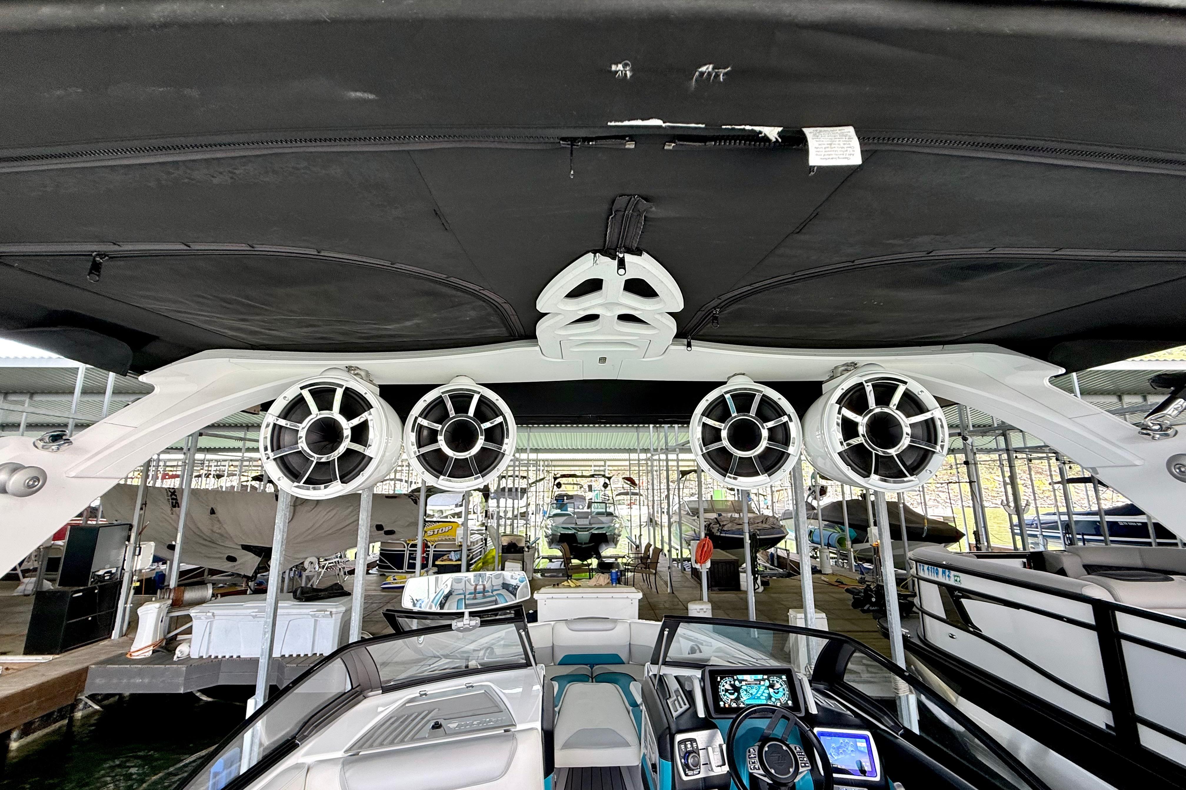 2017 Malibu M235 boat interior with speakers and dashboard in a marina setting.