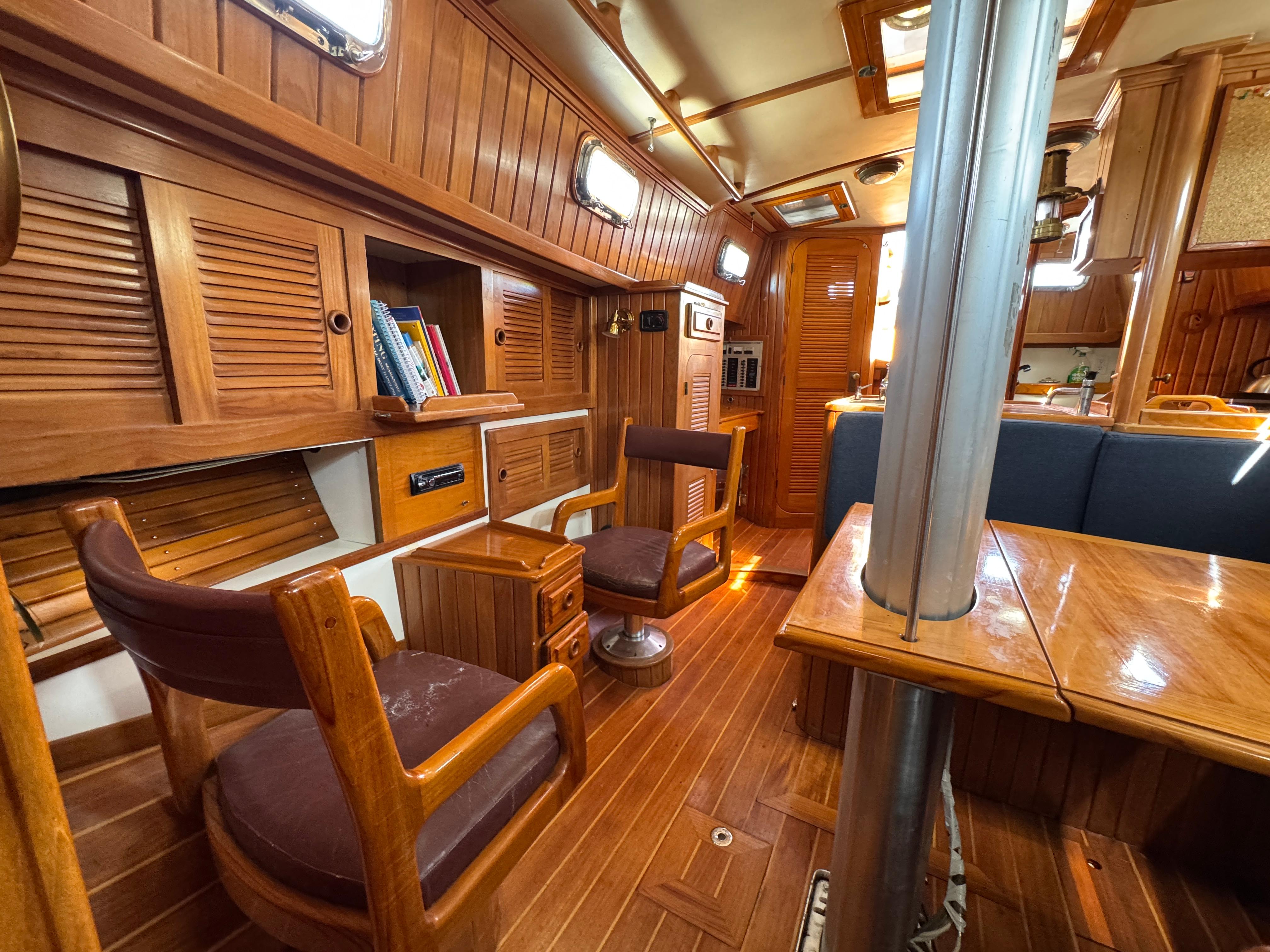 Interior of 1988 Cabo Rico 38XL sailboat with wooden furnishings and cozy seating.