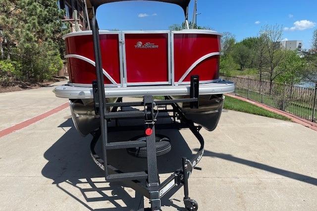 2026 Sun Tracker Party Barge 16 DLX pontoon boat on trailer, parked outdoors.