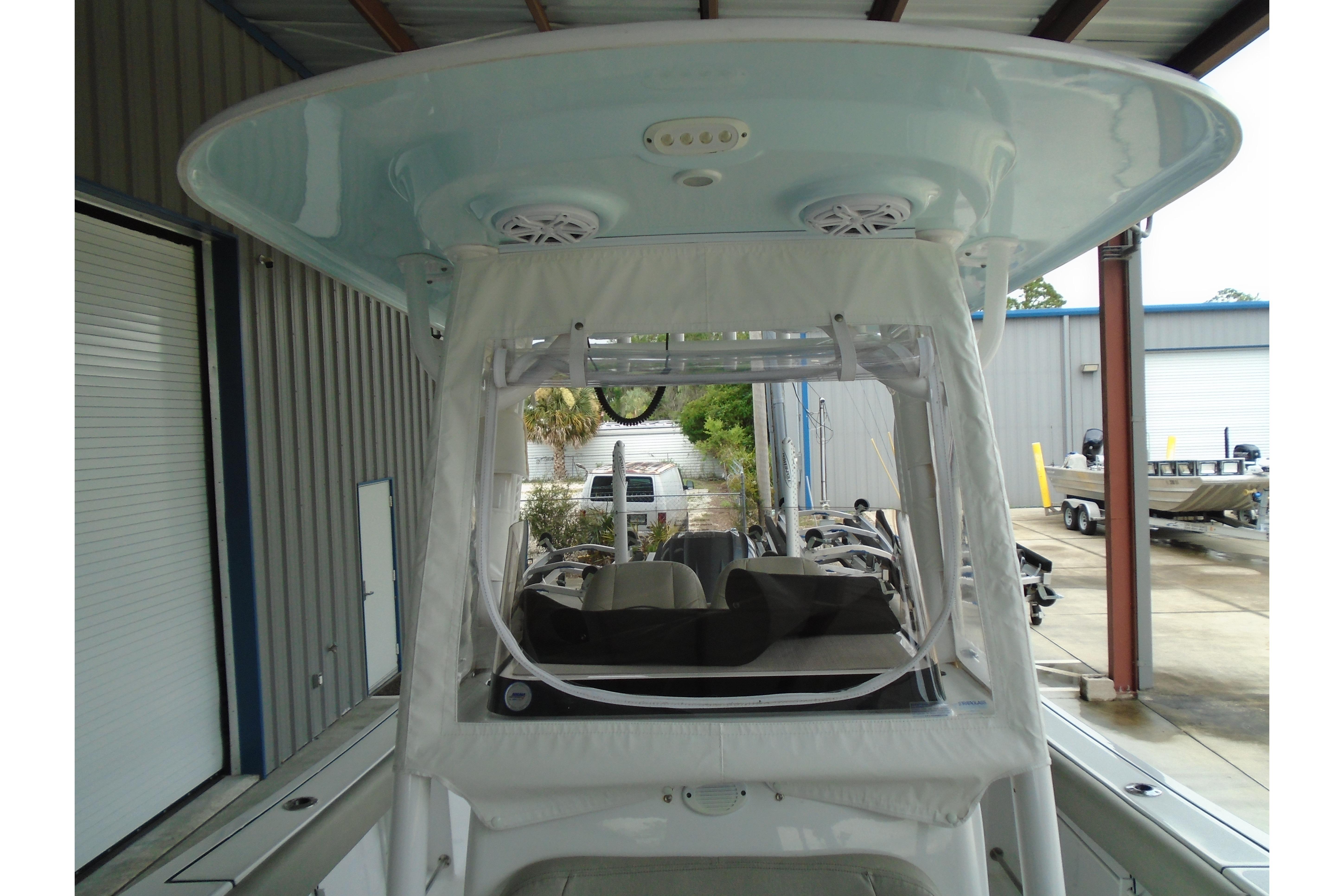2022 Sportsman Heritage 241 Center Console boat under a covered dock, showcasing helm and seating area.