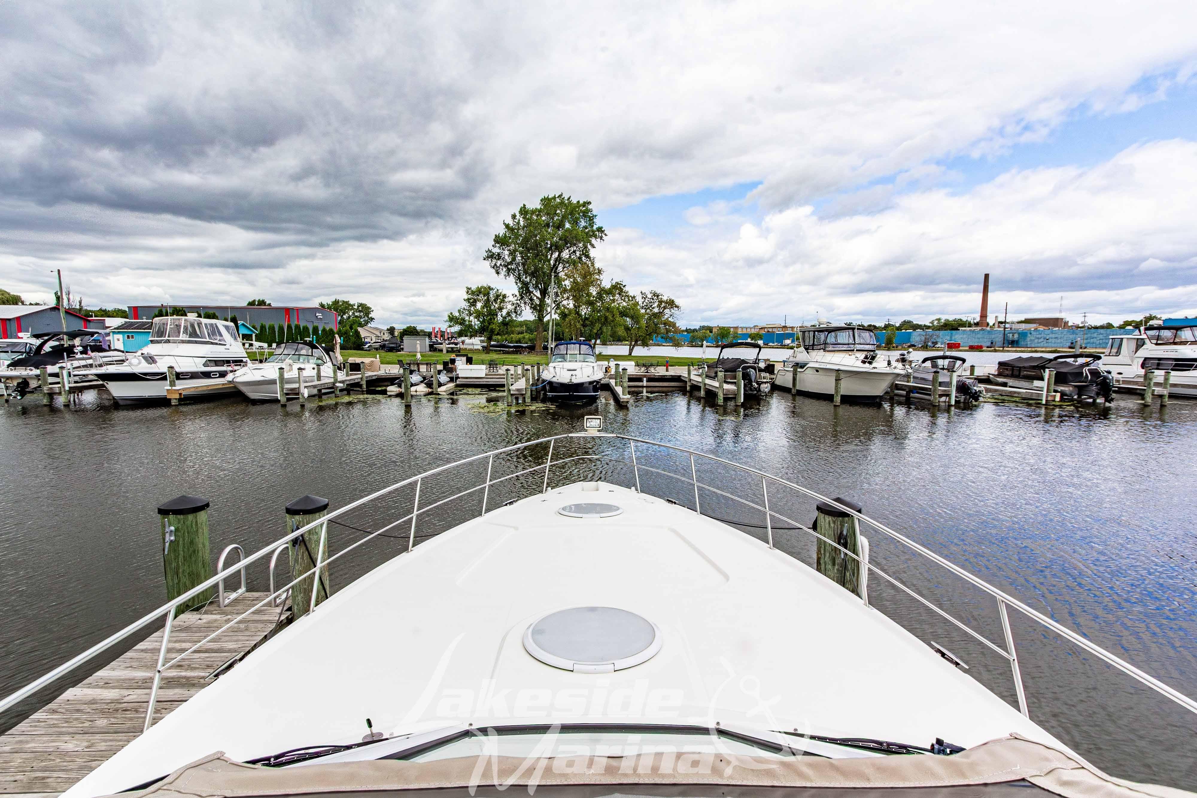 2006 Cruisers Yachts 420 Express docked at a marina under cloudy skies.